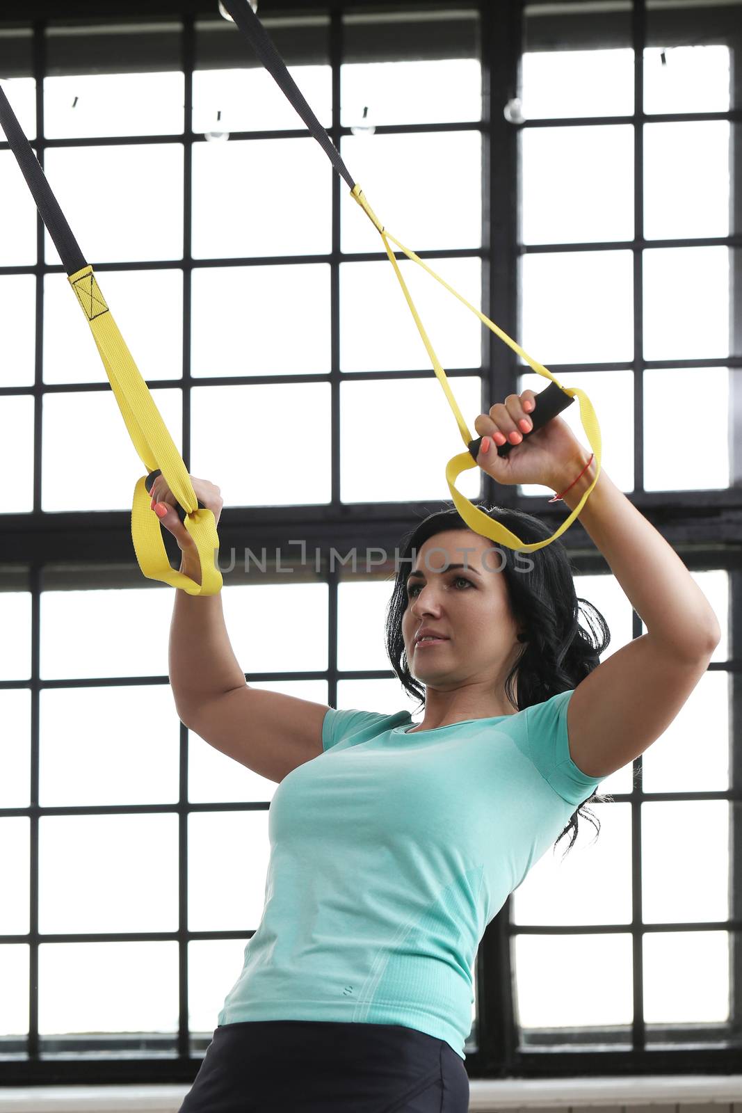 TRX. Beautiful woman at gym