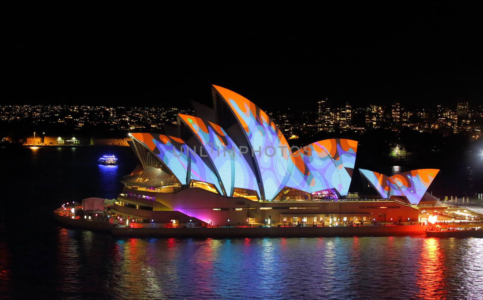 SYDNEY, AUSTRALIA - MAY 27, 2015; The Sydney Opera House comes alive each night during Vivid Sydney...  instead of the usual white lights lighting up its unique roof shape, these beautiful colours and patterns adorn it.  Here the roof alight in vivid orange and blue   8000 iso