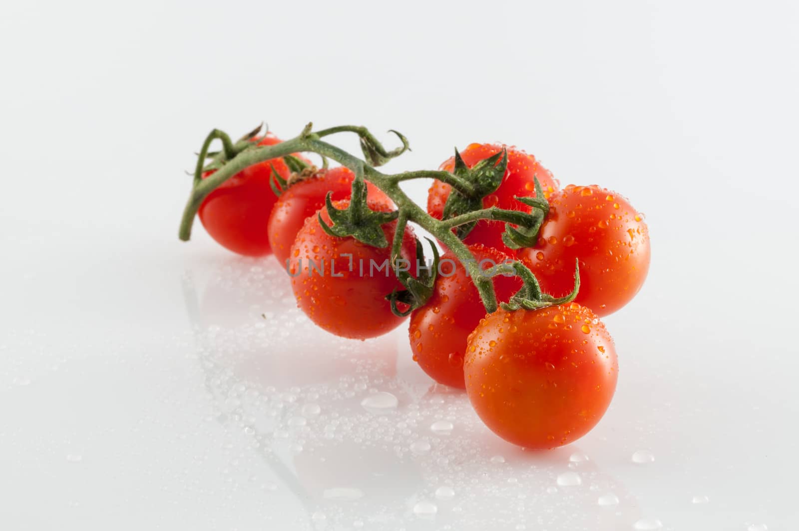 Small tomatoes on white background with reflections