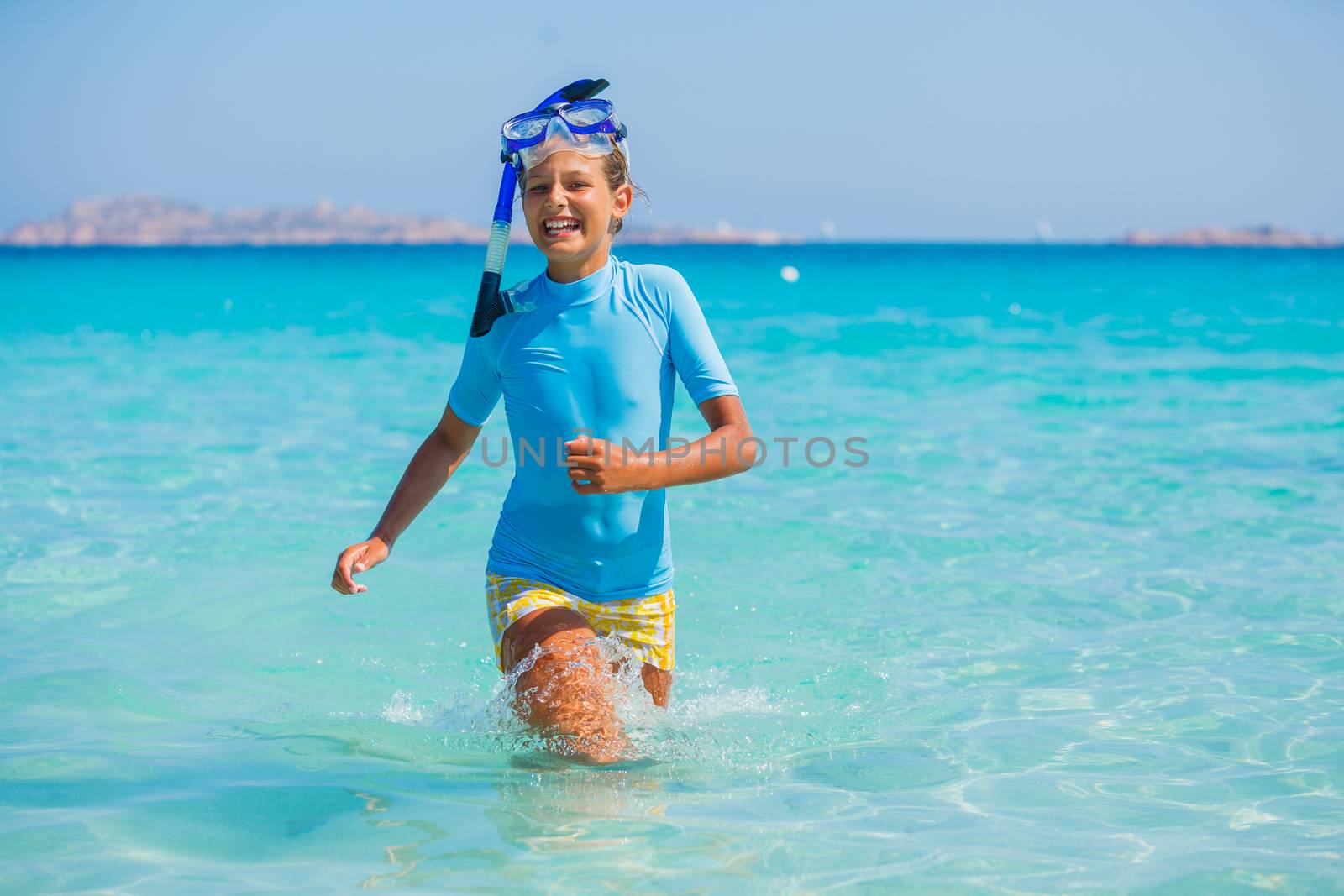 Happy cute girl wearing snorkeling mask ready to dive in the sea