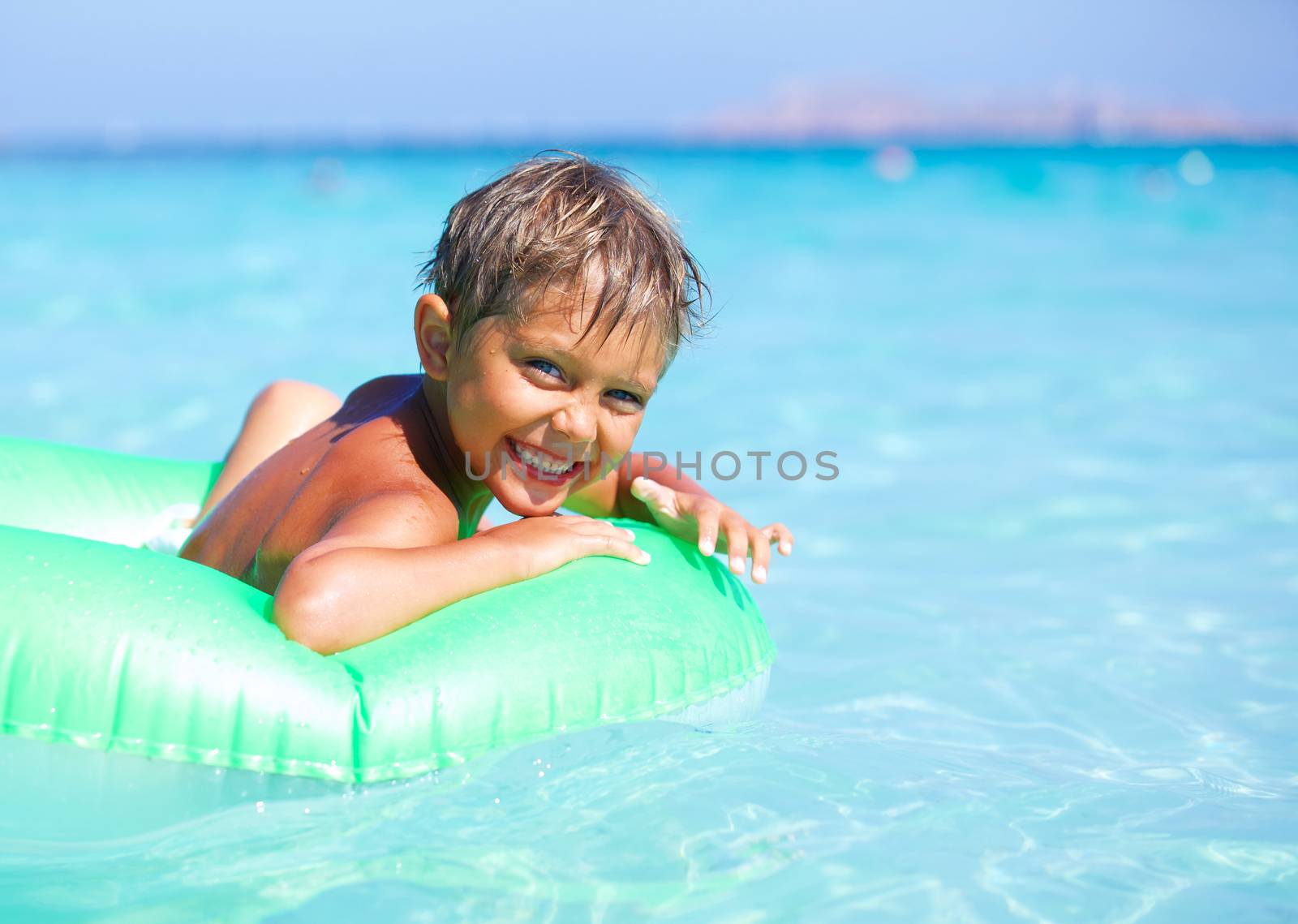 Happyboy playing on the inflatable rubber circle in the sea