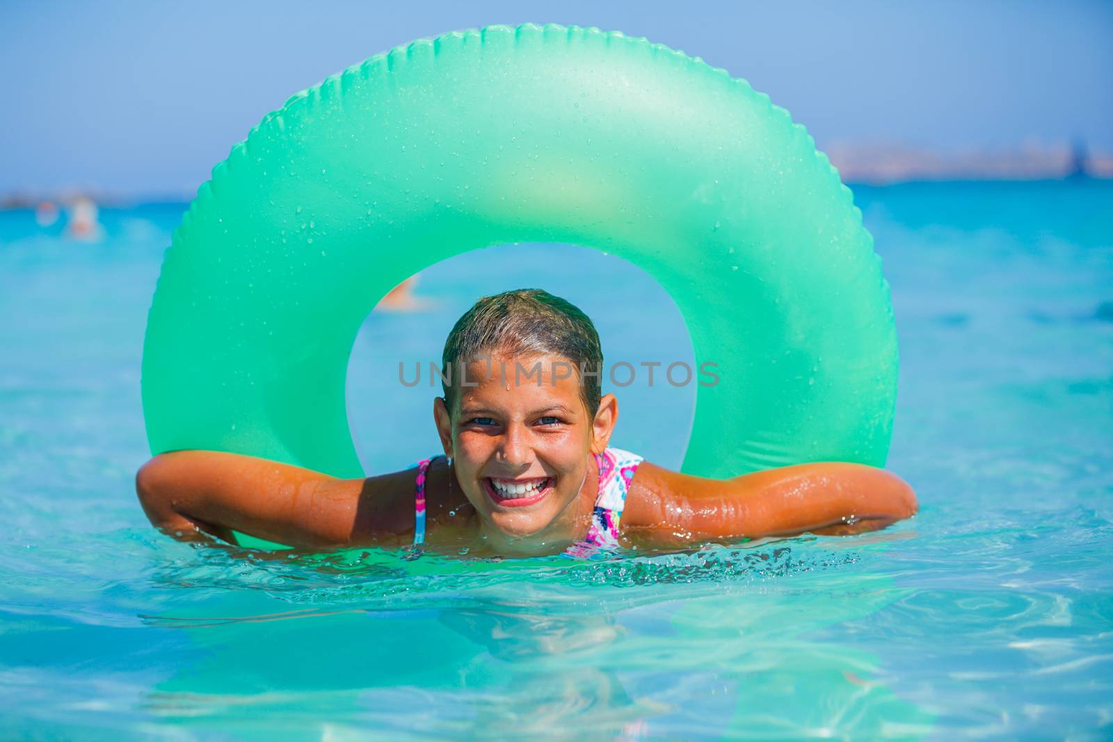 Beautiful girl relaxing on the inflatable rubber circle in the sea