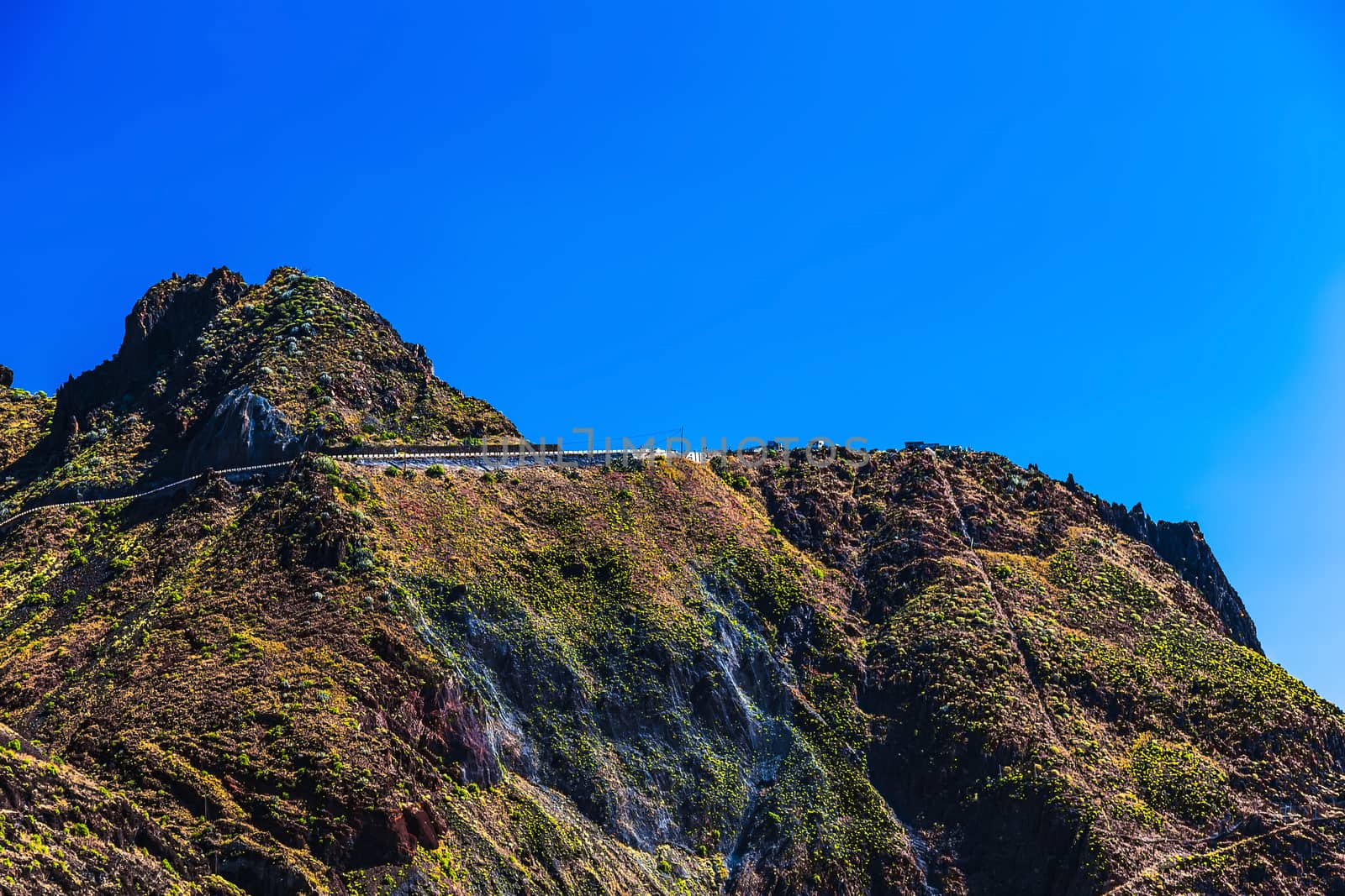 Winding road high in mountain or rock with blue sky in Tenerife Canary island, Spain at spring or summer