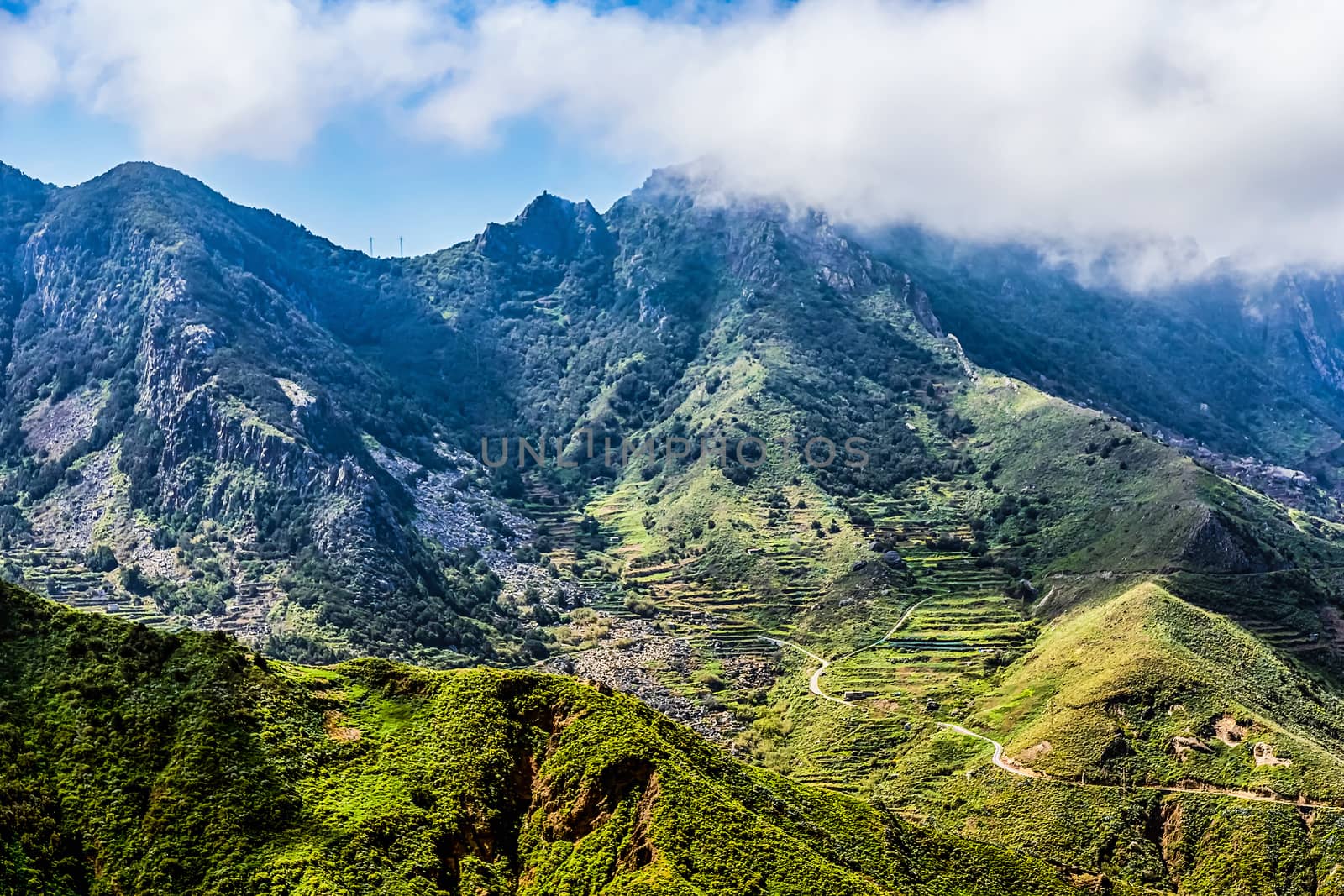 Mountains or rock with clouds over peak and road