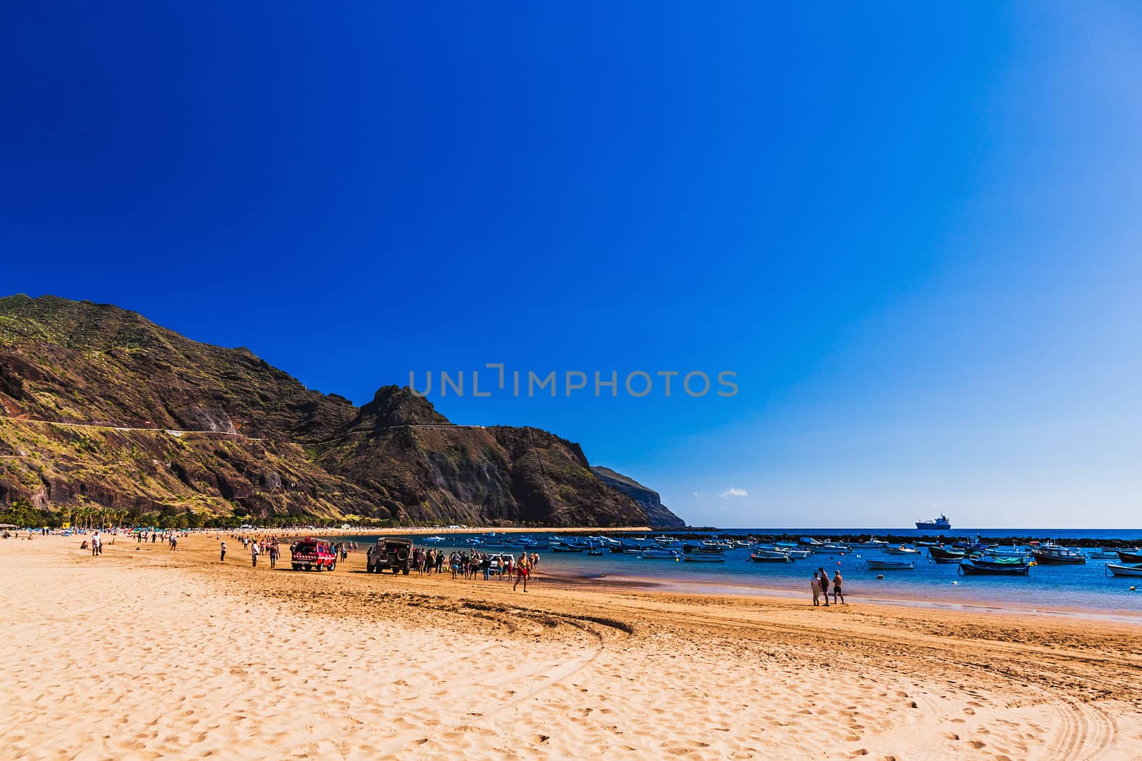 Beach Las Teresitas with yellow sand on coast or shore of Atlantic ocean on Tenerife Canary island, Spain. Mountain at the background