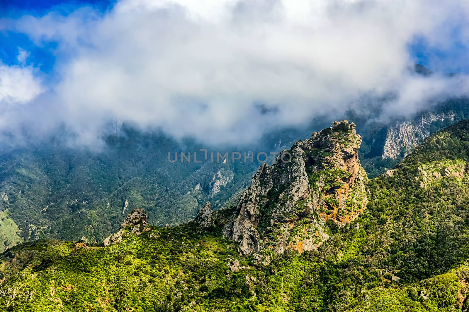 Rocks and green mountain with clouds