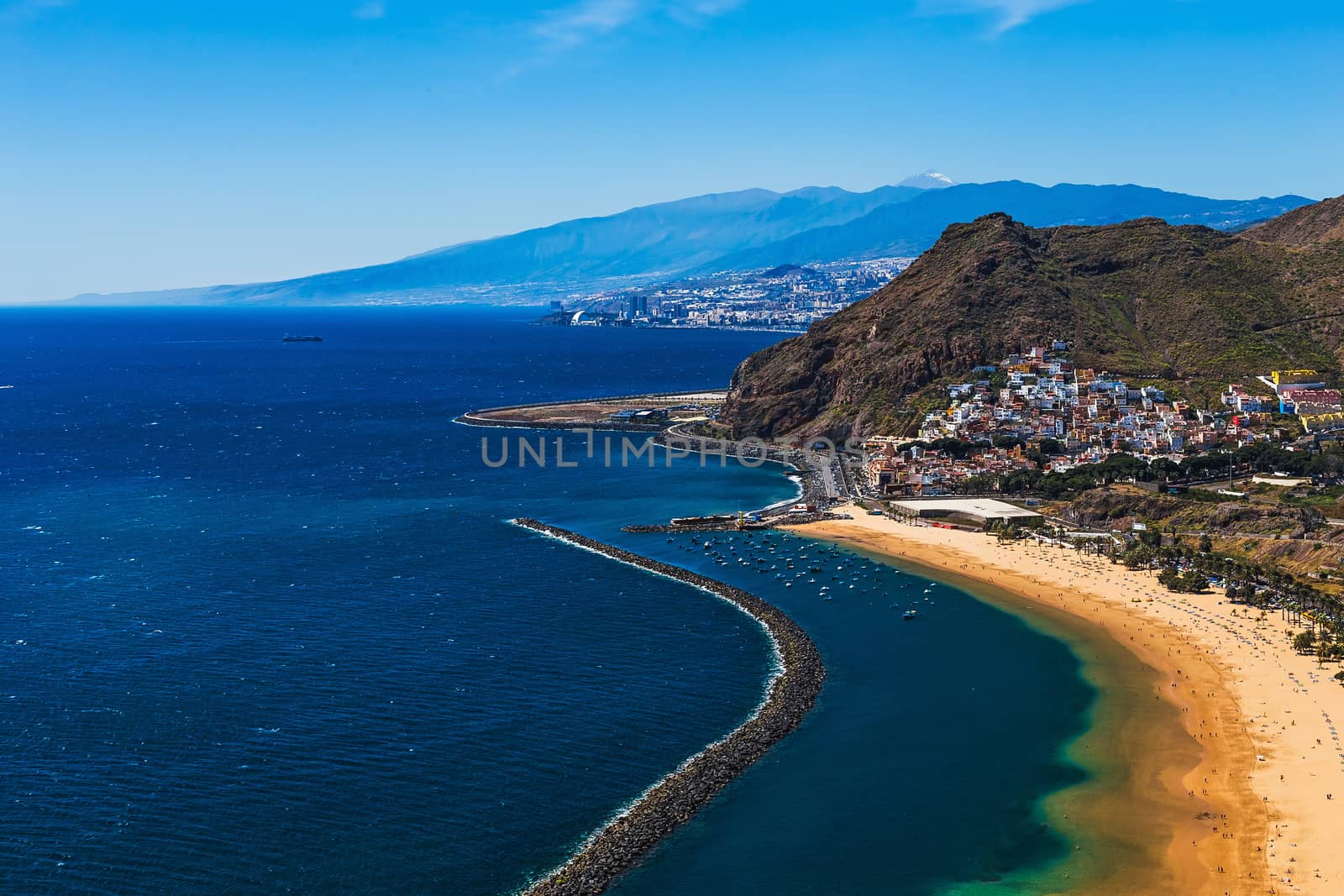 Coast of Atlantic ocean and beach Las Teresitas in Santa Cruz city on Tenerife Canary island, Spain at spring or summer. Teide volcano at background