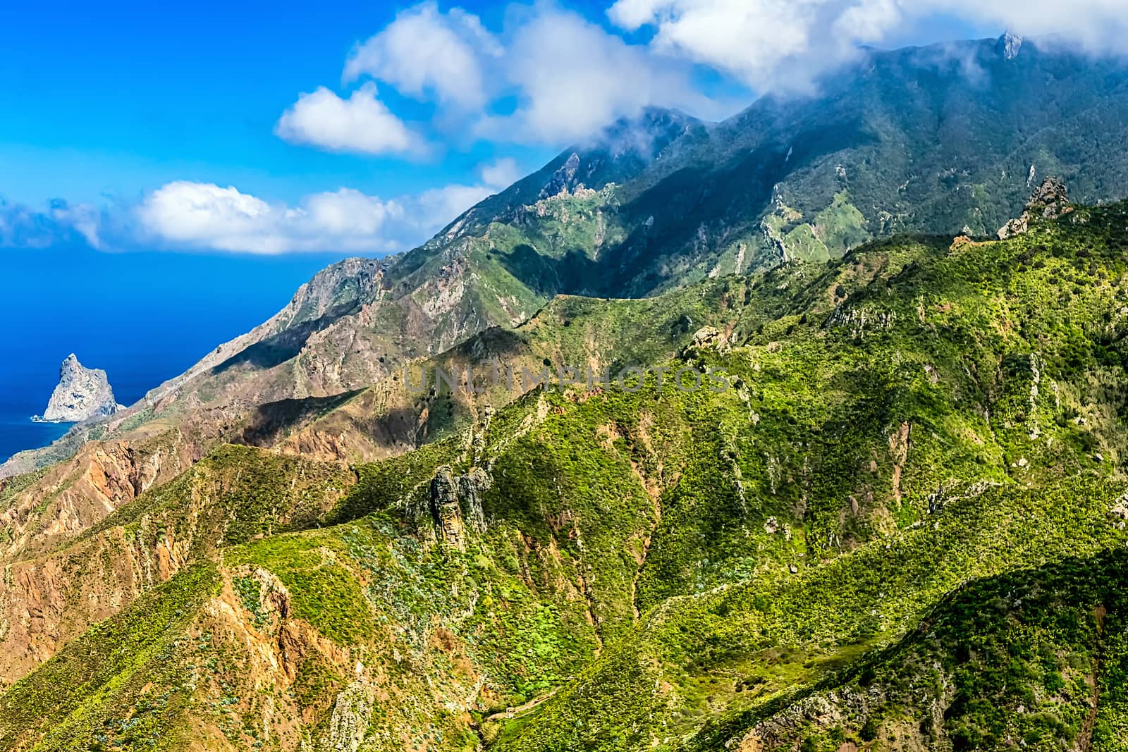 Clouds and green mountains or rocks  near the Atlantic ocean landscape in Tenerife Canary island, Spain