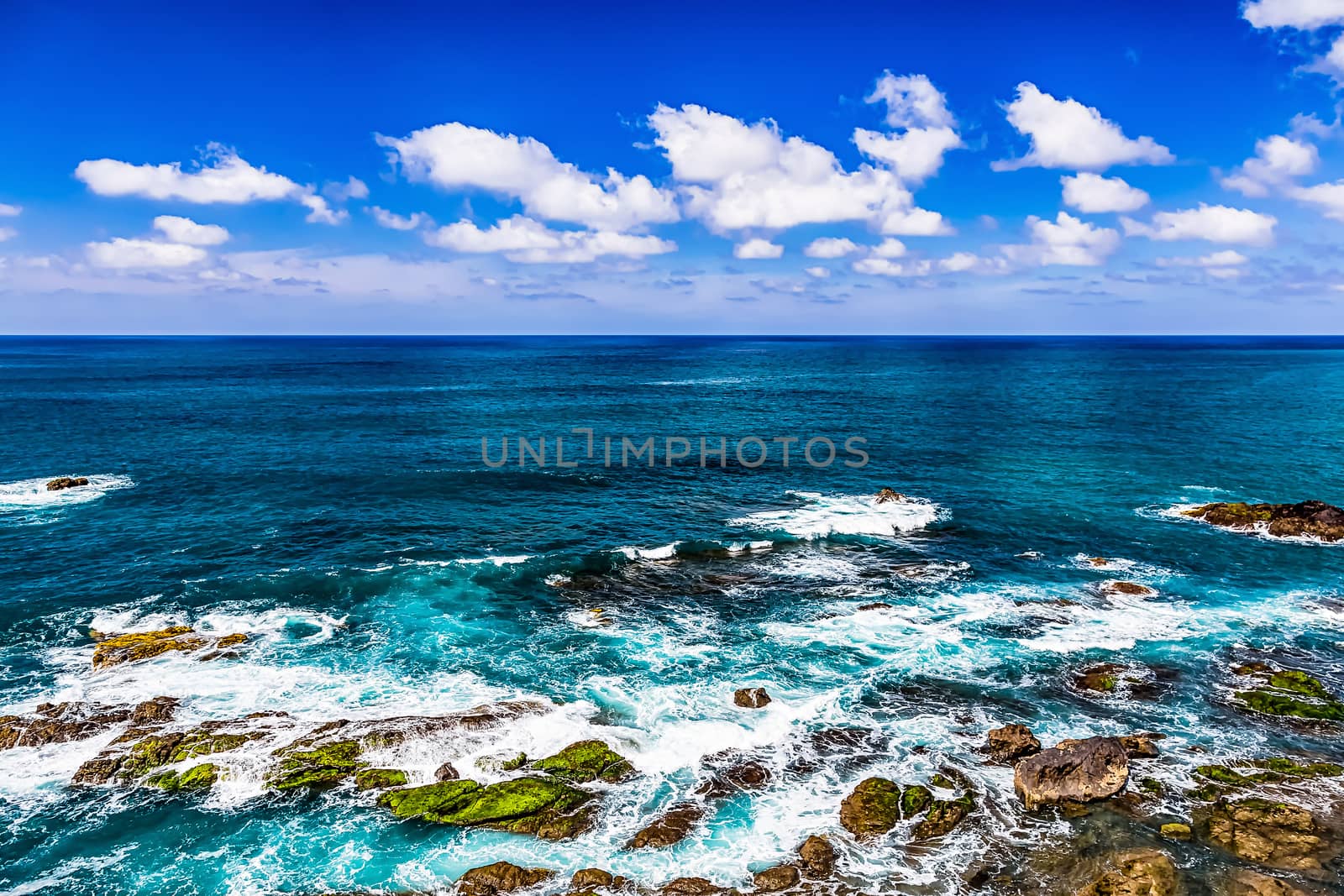 Stone shore of Atlantic ocean and sky with clouds and skyline or horizon landscape in Tenerife Canary island, Spain at spring or summer