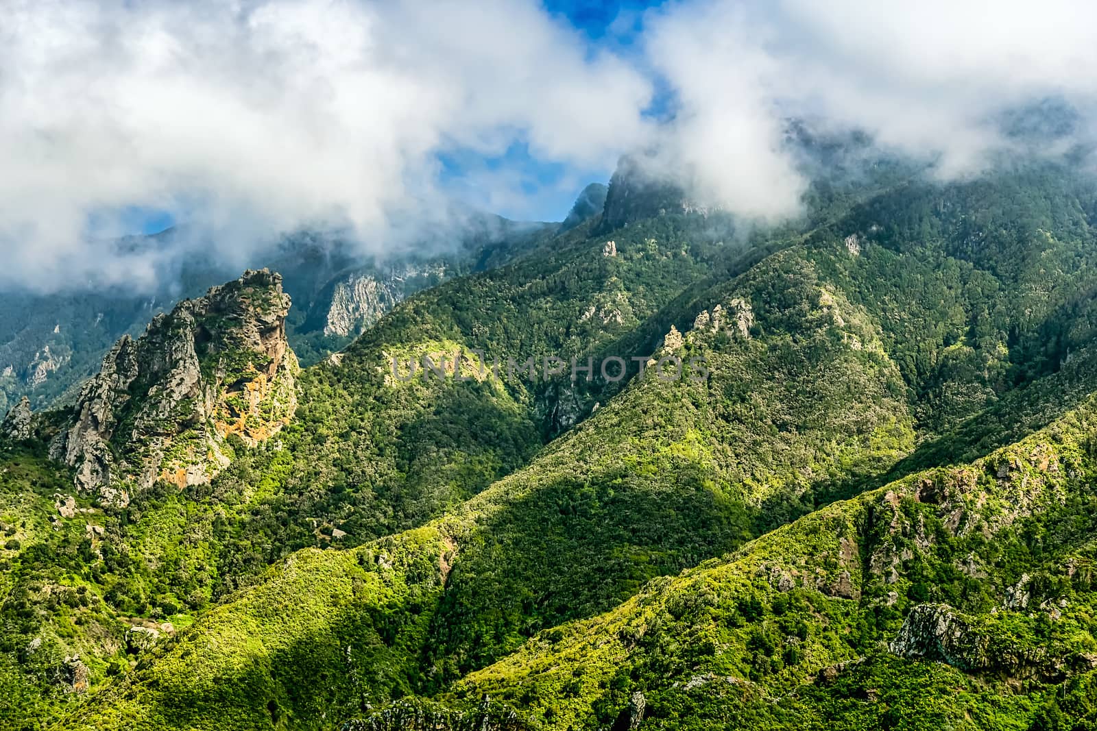 Green mountain and rocks with clouds