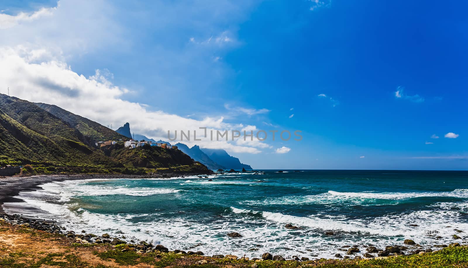 Coast or shore of Atlantic ocean with  mountain or rock and blue sky with clouds and skyline or horizon in Tenerife Canary island, Spain at spring or summer