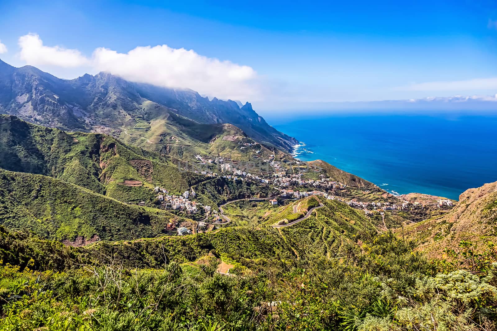 Mountain and clouds with small city or village and sky horizon landscape near the coast of Atlantic ocean in Tenerife Canary island, Spain