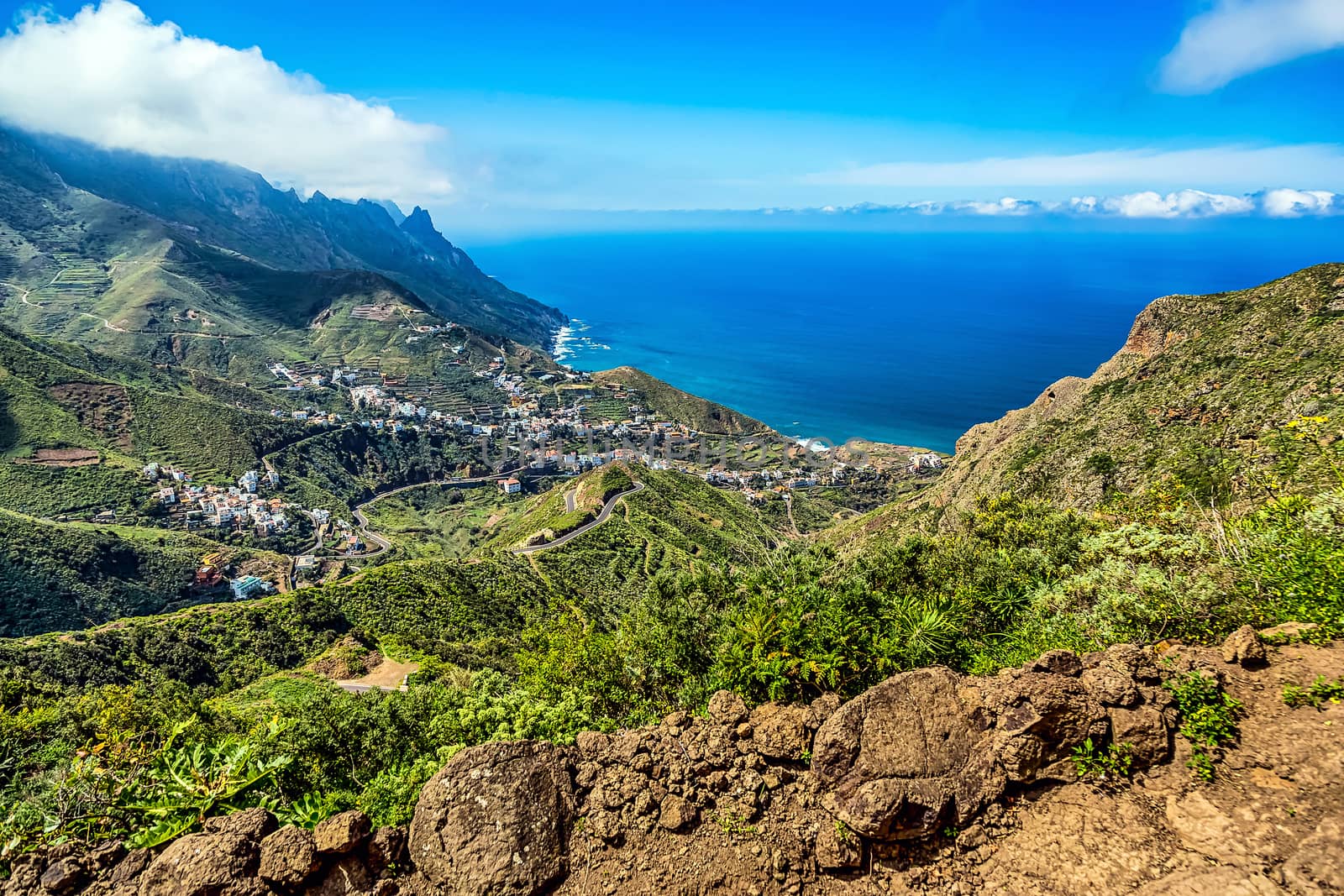 Mountain and clouds with small town or village and sky horizon landscape near the coast of ocean in Tenerife Canary island, Spain