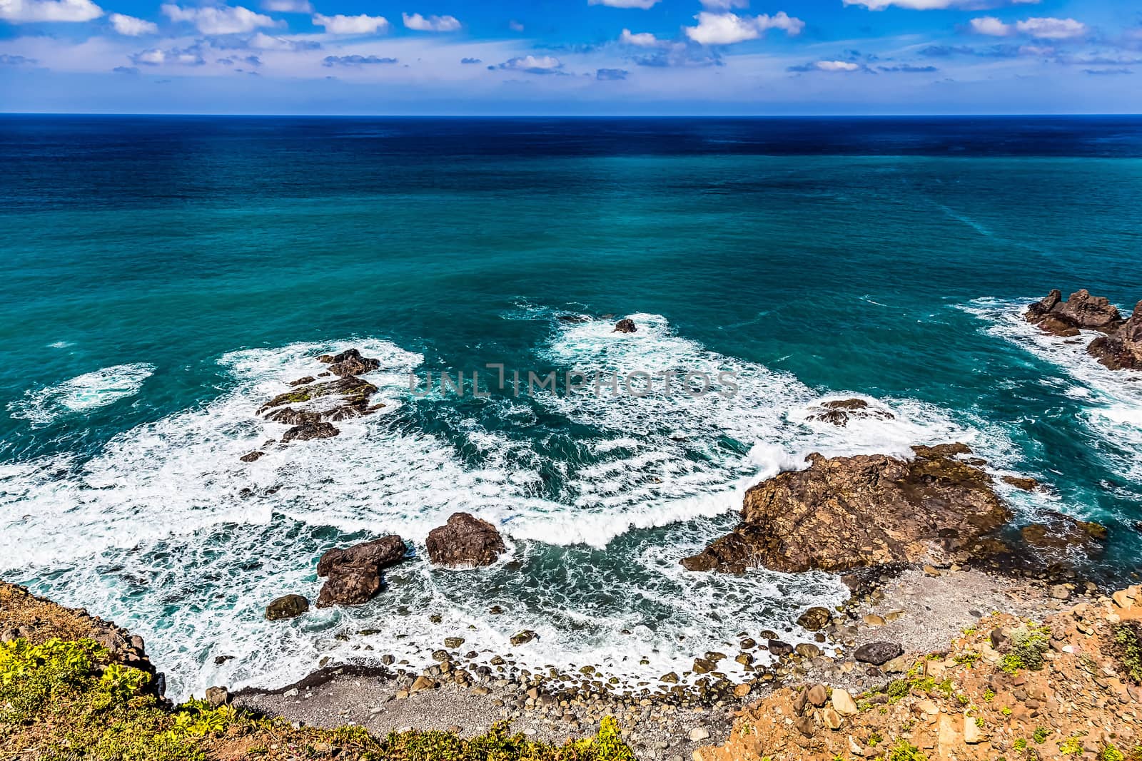 Stone coast or shore of ocean and sky with clouds and skyline or horizon landscape in Tenerife Canary island, Spain at spring or summer