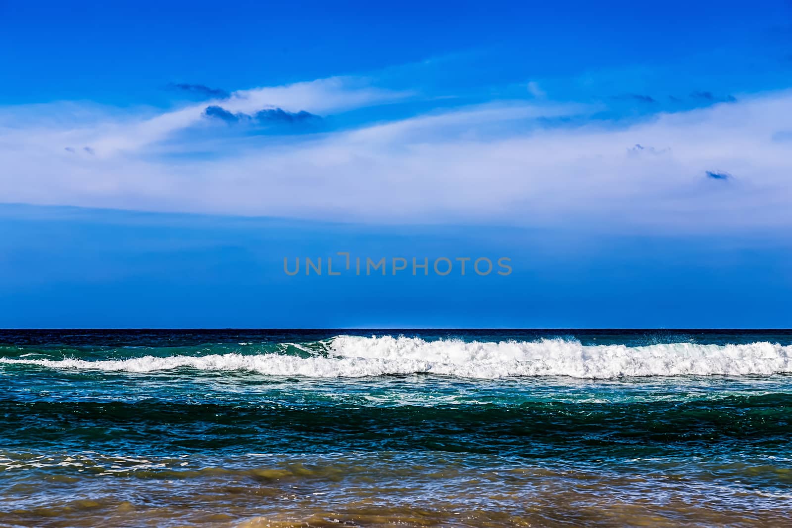 Atlantic ocean with waves and blue sky with clouds on background