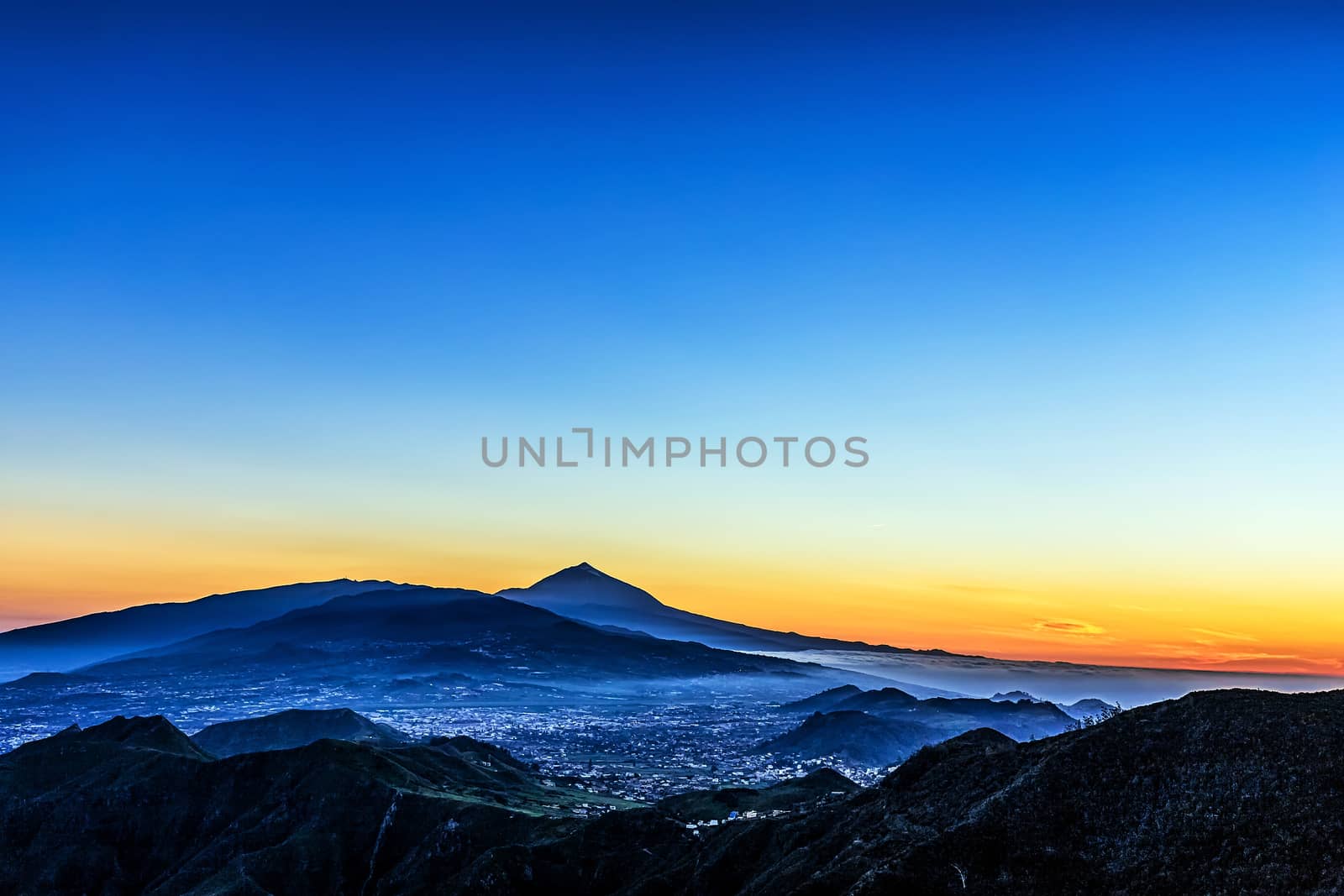 Sunset in mountains and blue sky with fog and Teide volcano on background in Tenerife Canary island, Spain at spring or summer