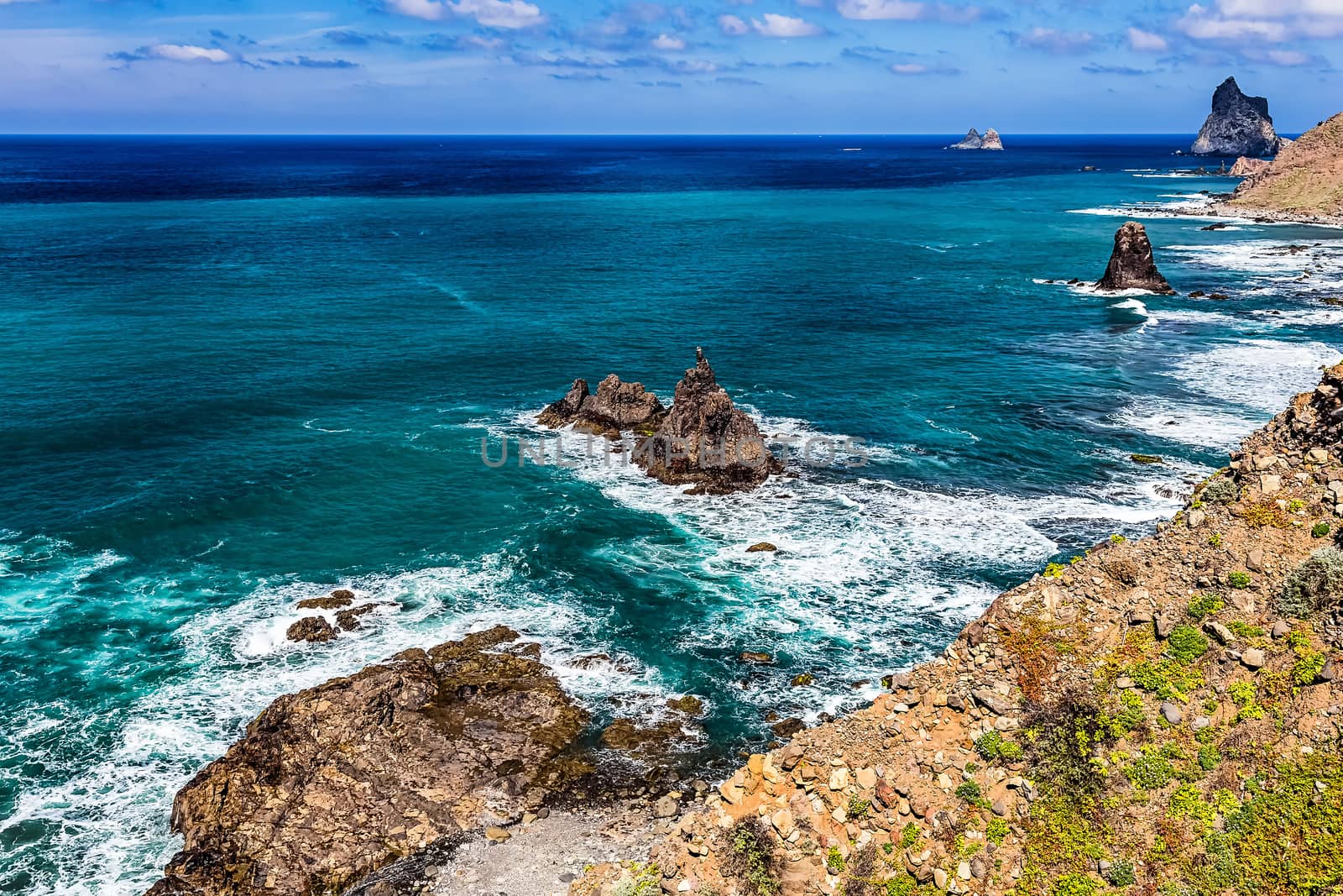 Stone shore with rocks of Atlantic ocean and sky with clouds and skyline or horizon landscape in Tenerife Canary island, Spain at spring or summer
