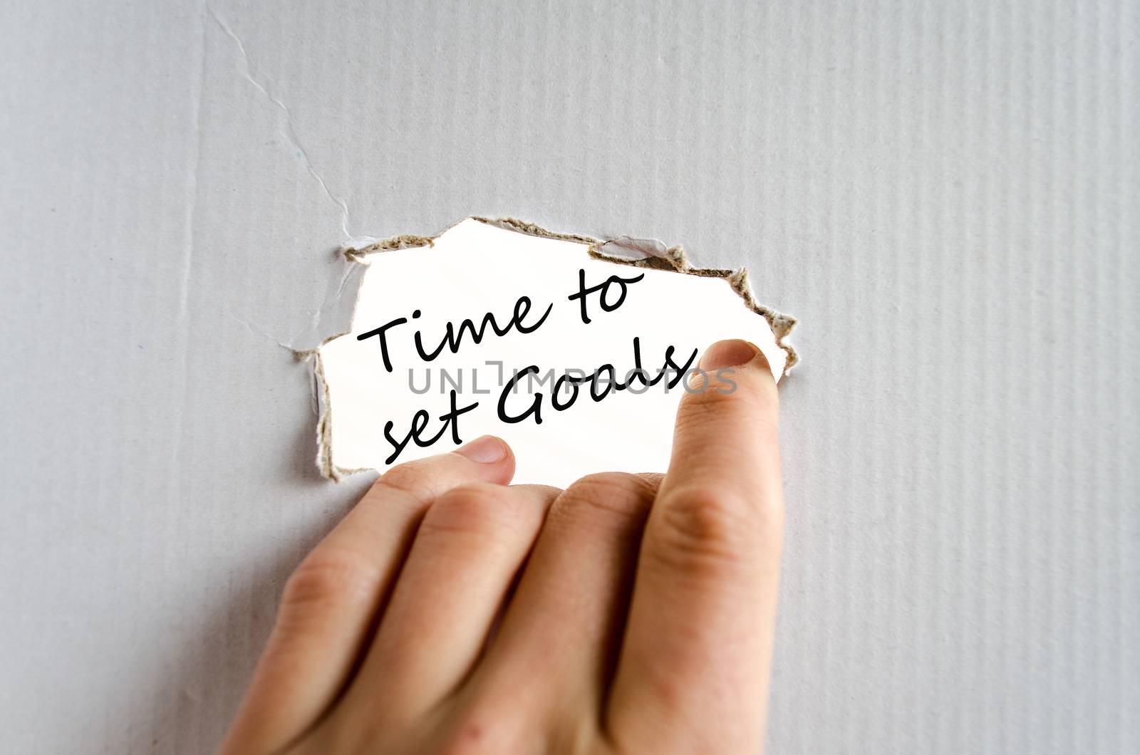 Hand and text on the cardboard background Time to set goals