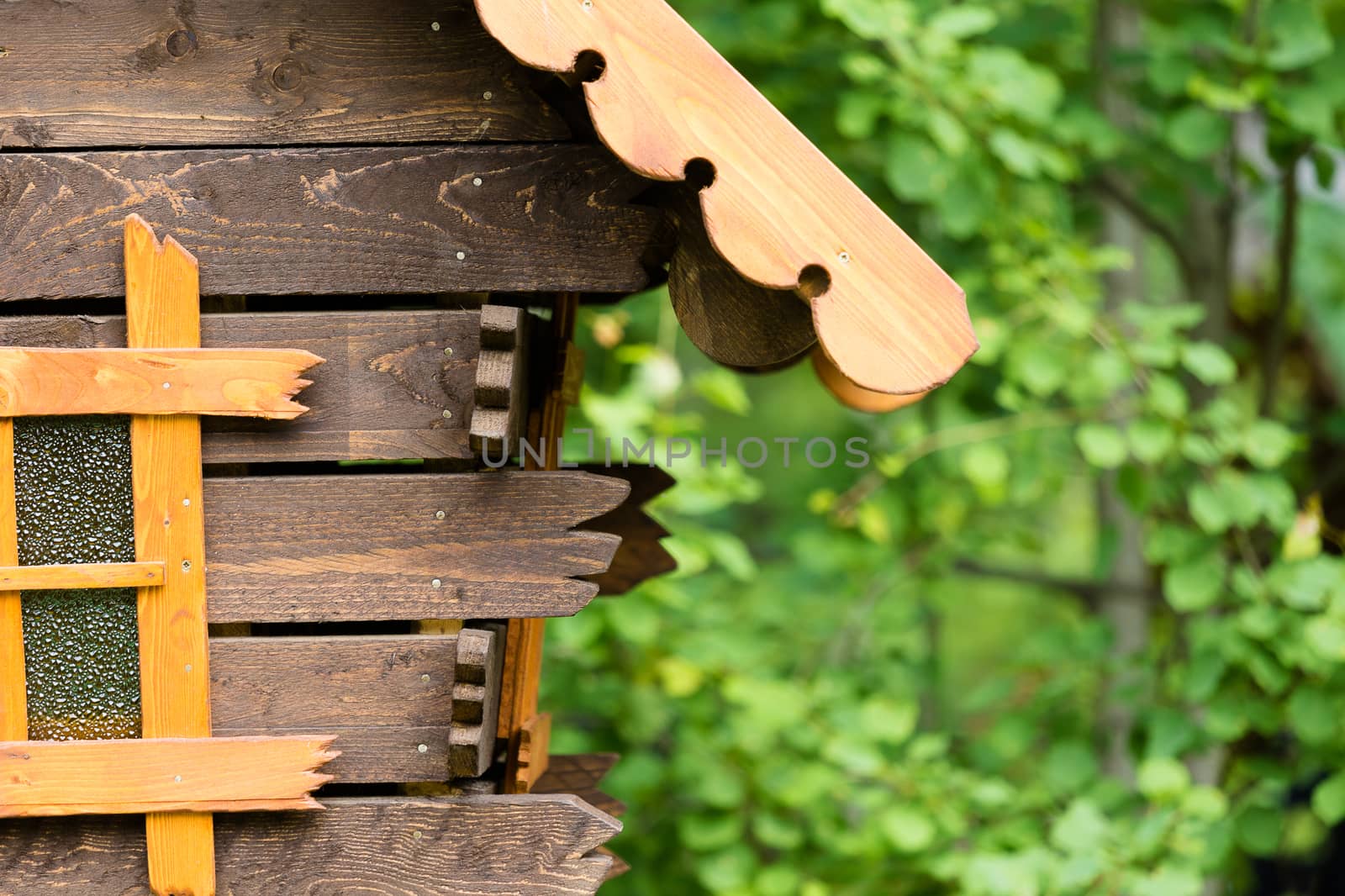 Decorative log hut in the park on a background of trees