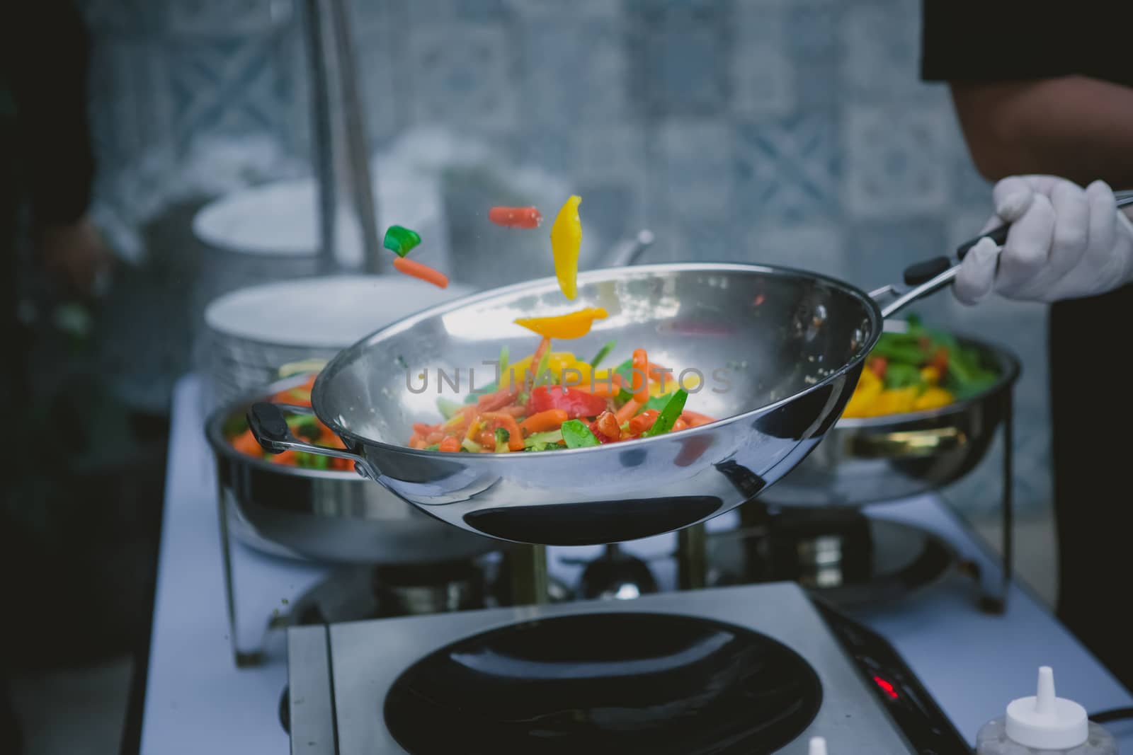 Chef cooking vegetables in wok pan. Shallow dof