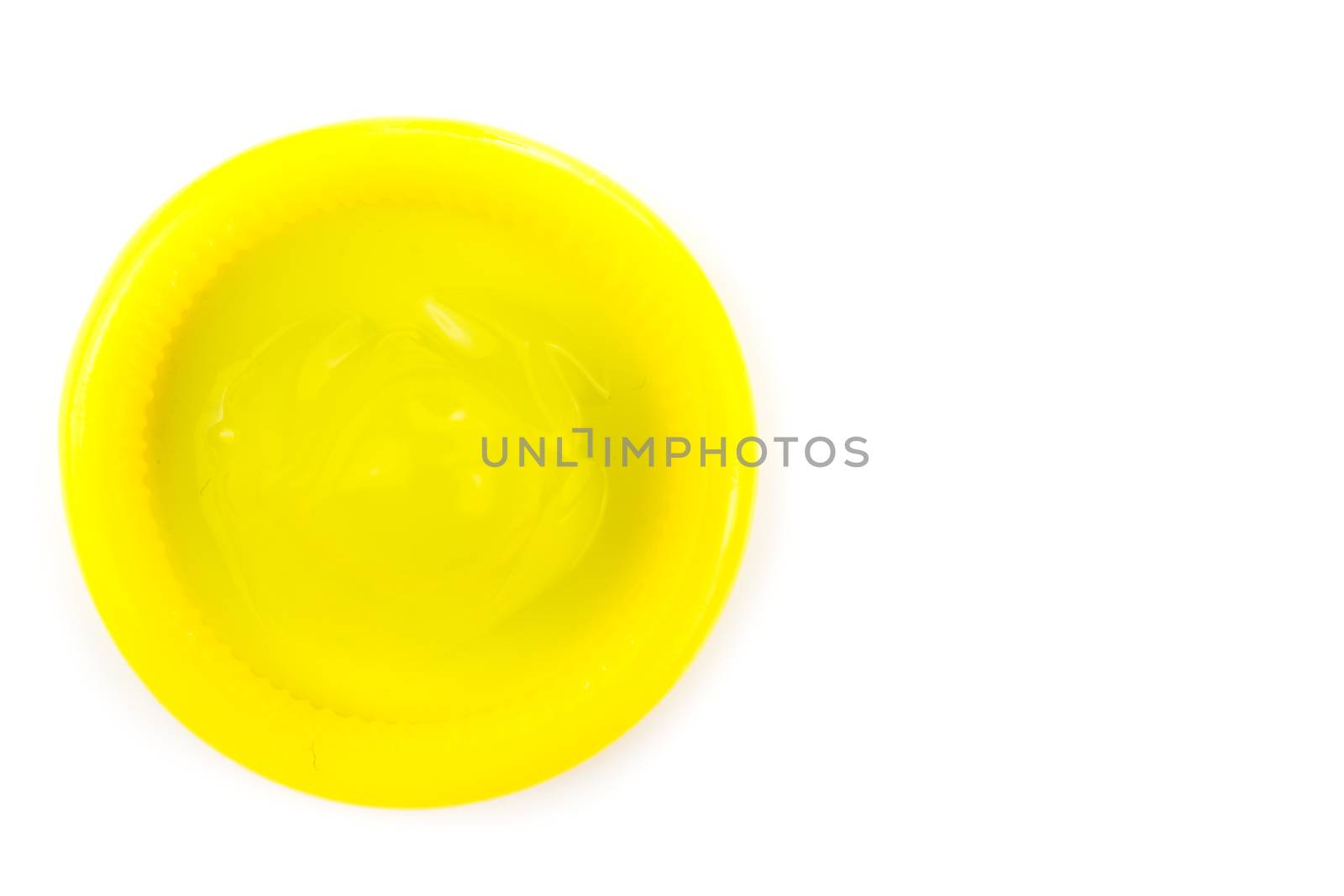 yellow condom on white background from topview