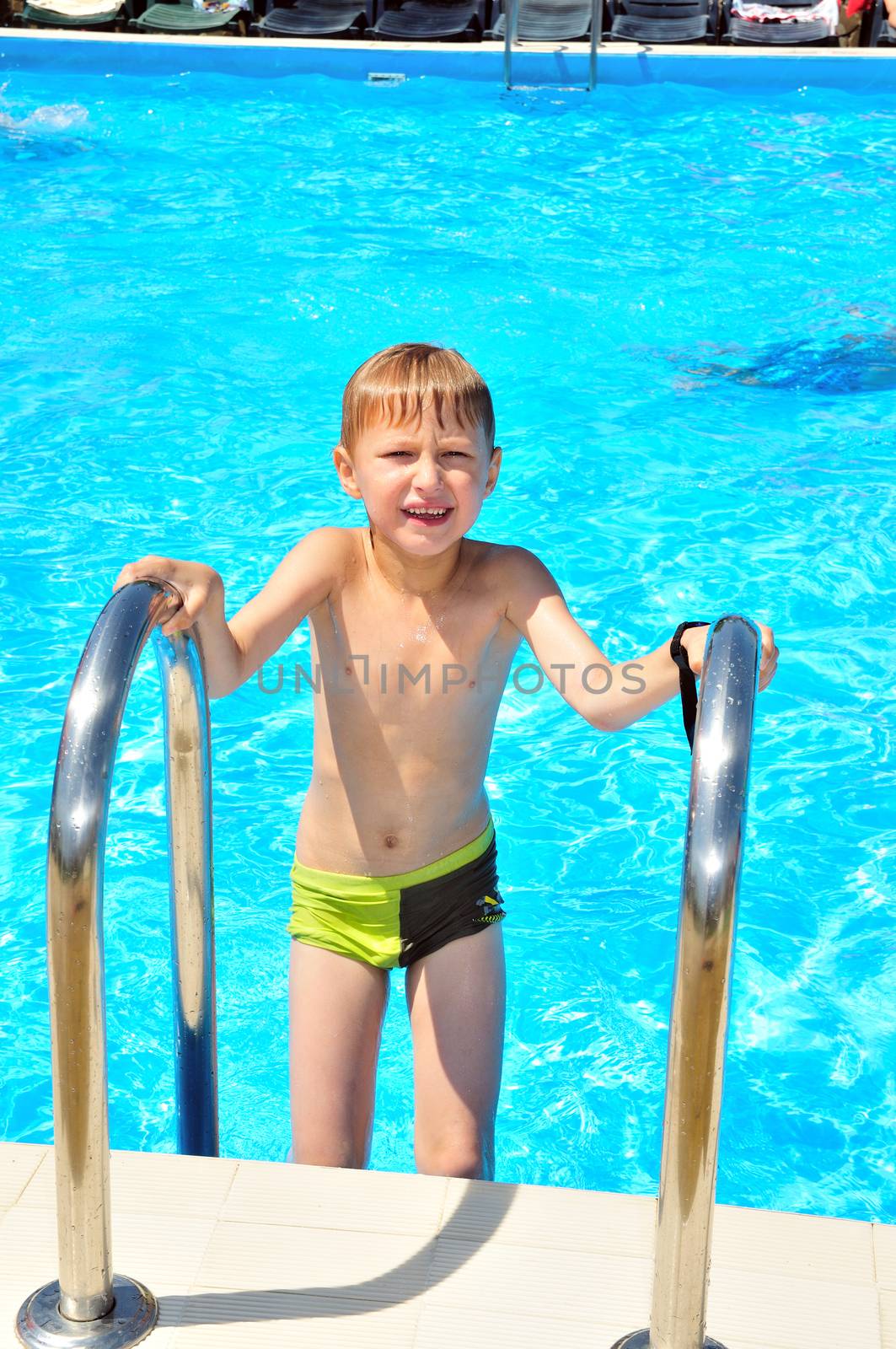 little slim boy  gettinh out from swimming pool 