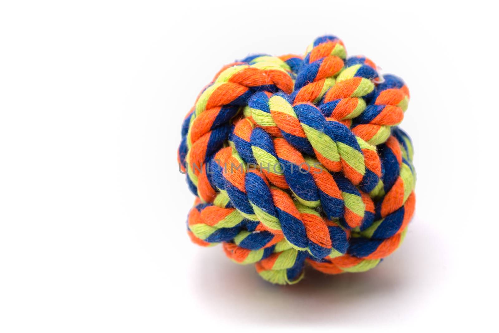 A very colorful ball made from rope tied in a monkey's fist knot used for a dog's toy.