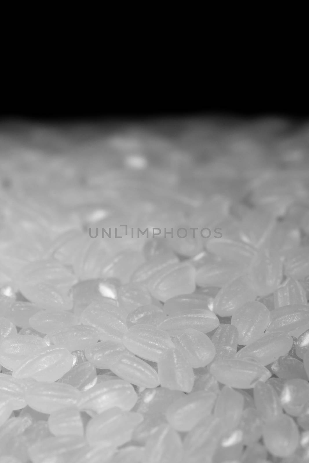 A close up shot of uncooked rice fading into a black background.