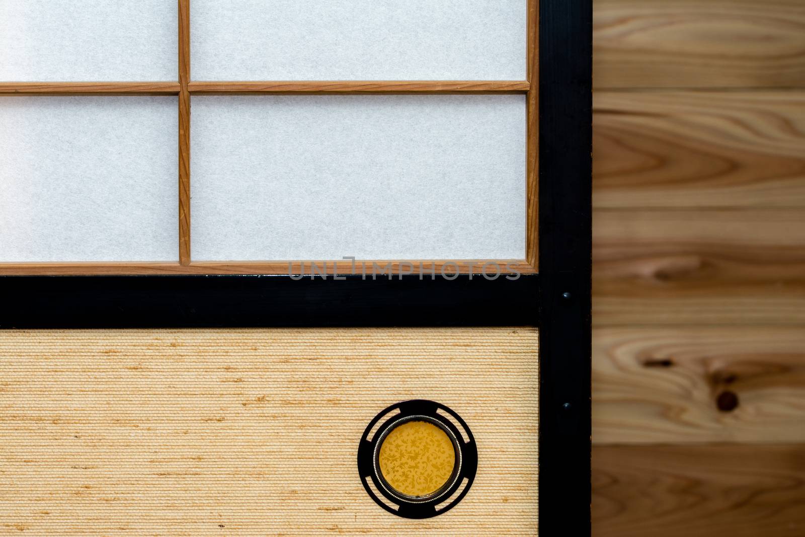 A Japanese sliding door called "shoji" or "fusuma" with a wooden wall in the background.