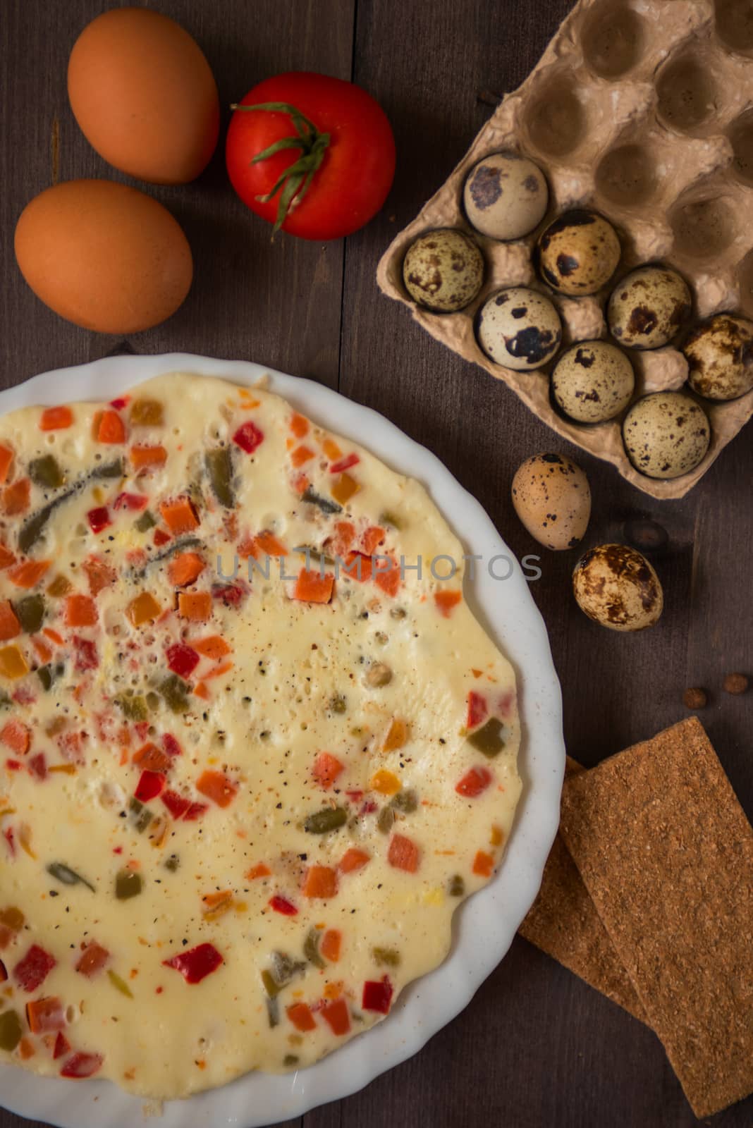 baked omelette with different eggs and vegetables with rye small load of bread