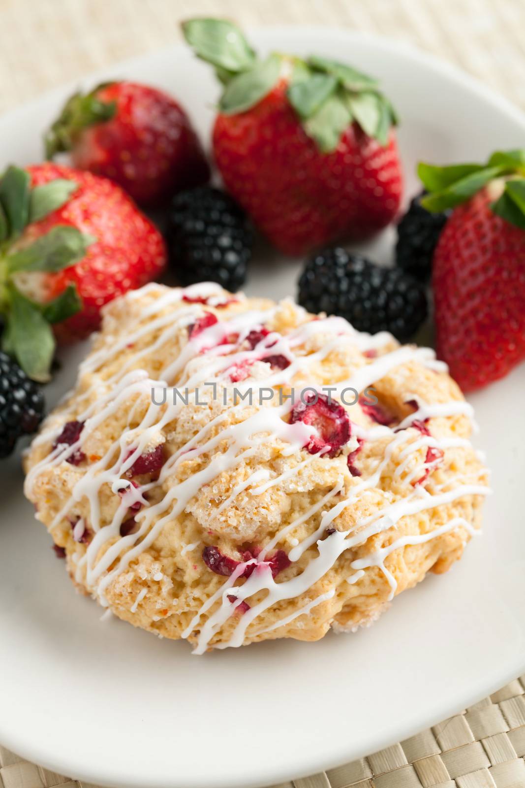 Orange Cranberry Scone with fresh fruit.  Shallow depth of field.