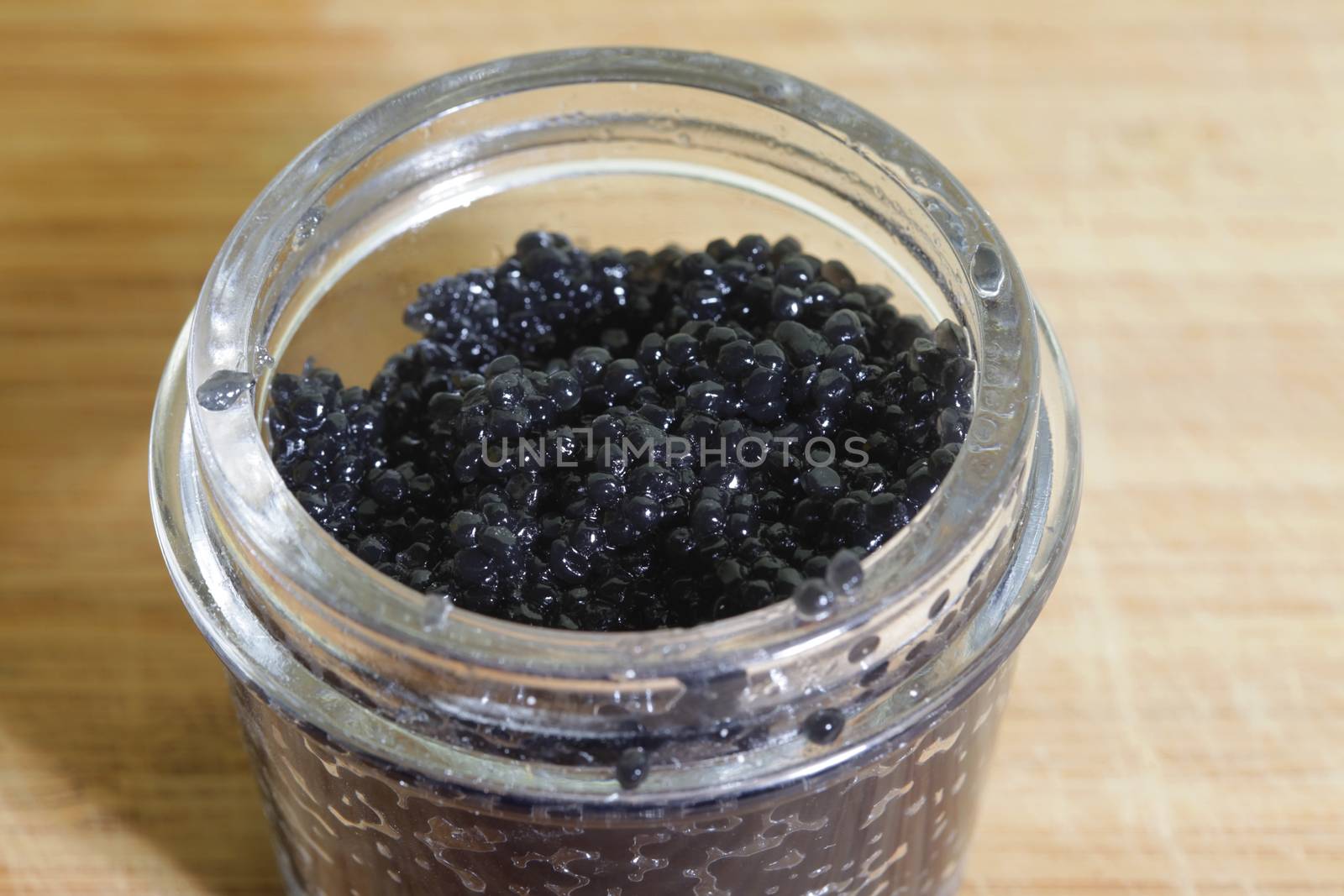 Black caviar in glass bank close-up