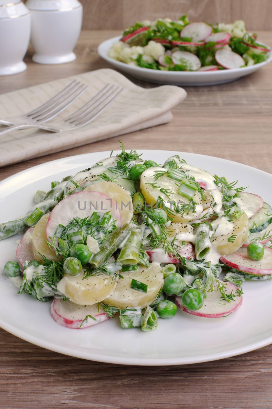 Potato salad with radishes, peas, beans in yogurt dressing