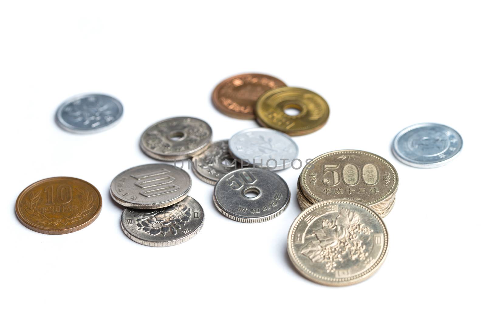 A mix of Japanese Yen coins spread out on a white background.