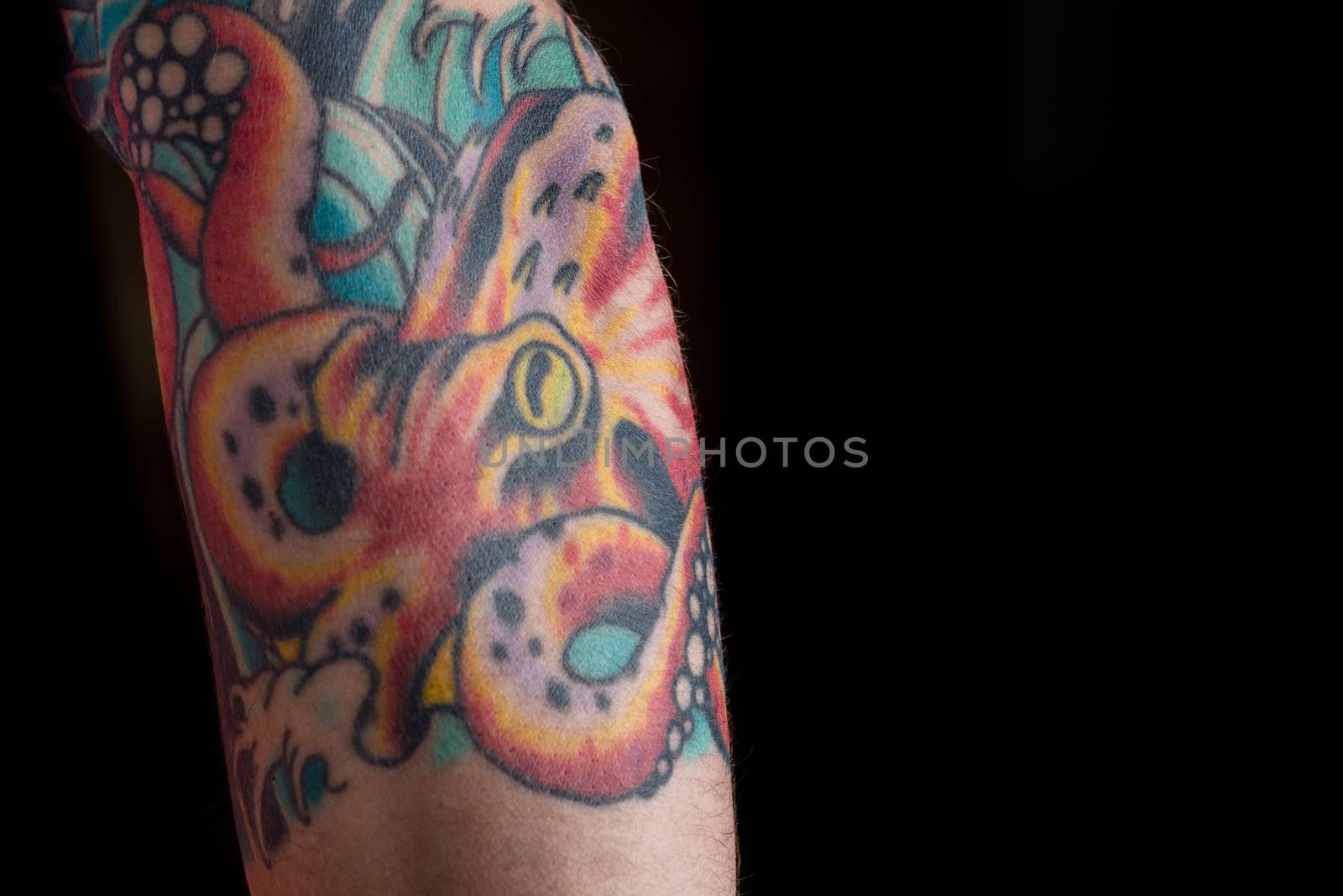 A tattoo of a red octopus on a black background.