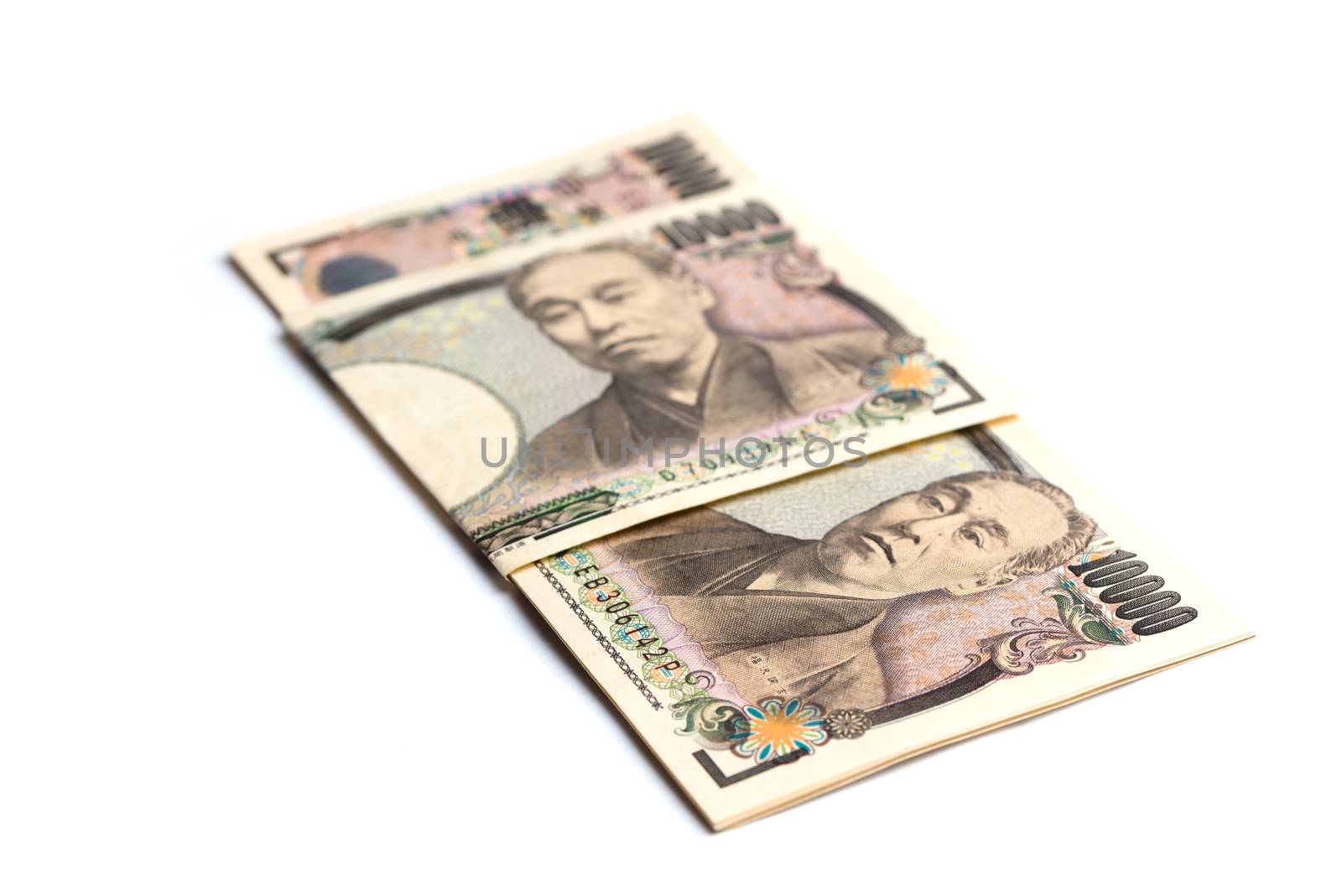 10,000 yen bills wrapped in a folded 10,000 yen bill isolated on white.