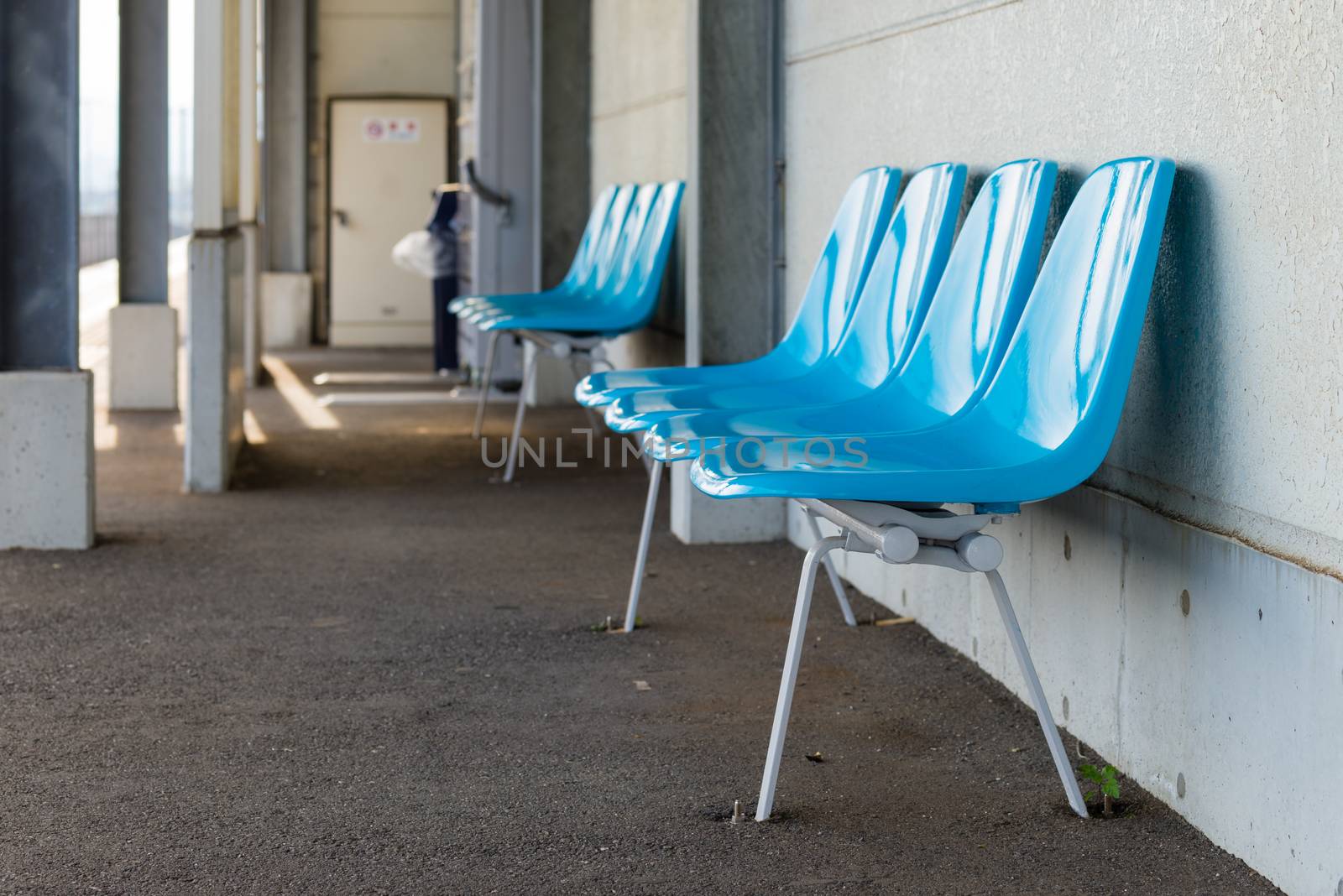 Empty plastic blue chairs at a train station in the countryside of Kochi, Japan.