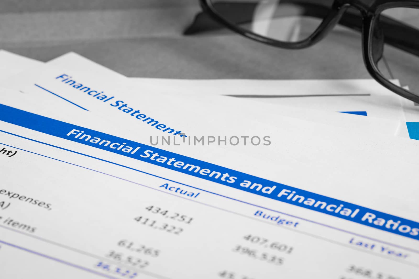 Financial statement letter on brown envelope and eyeglass, business concept; document is mock-up