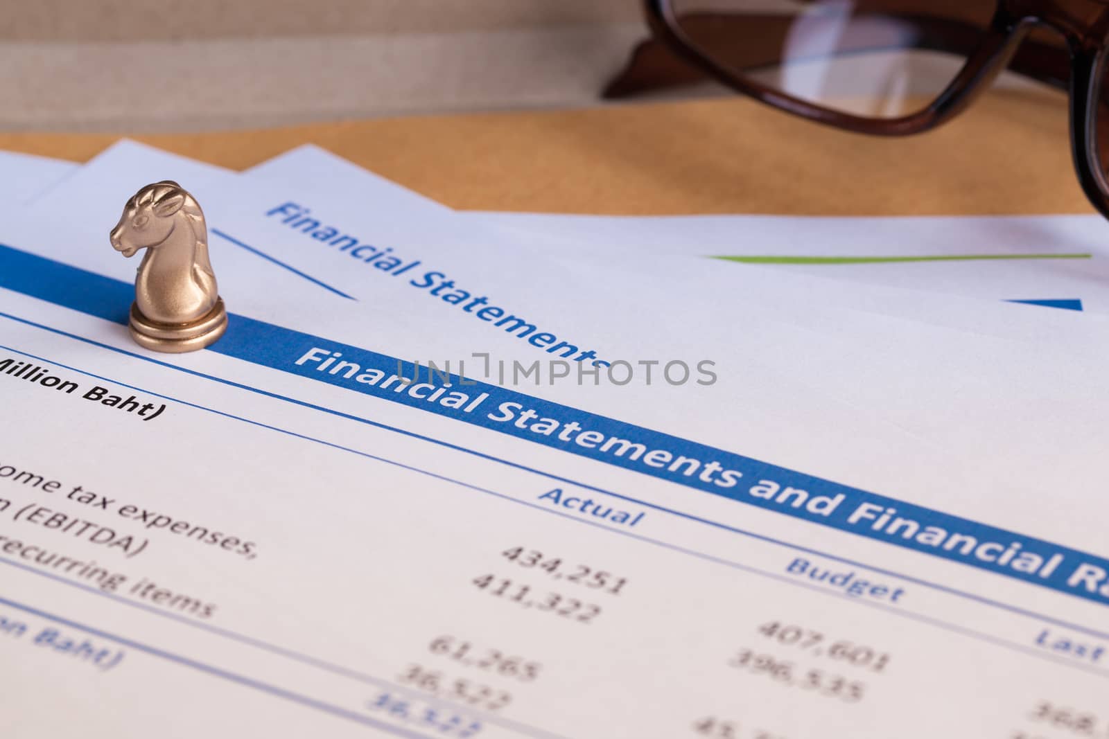 Financial statement letter on brown envelope and eyeglass, business concept; document is mock-up