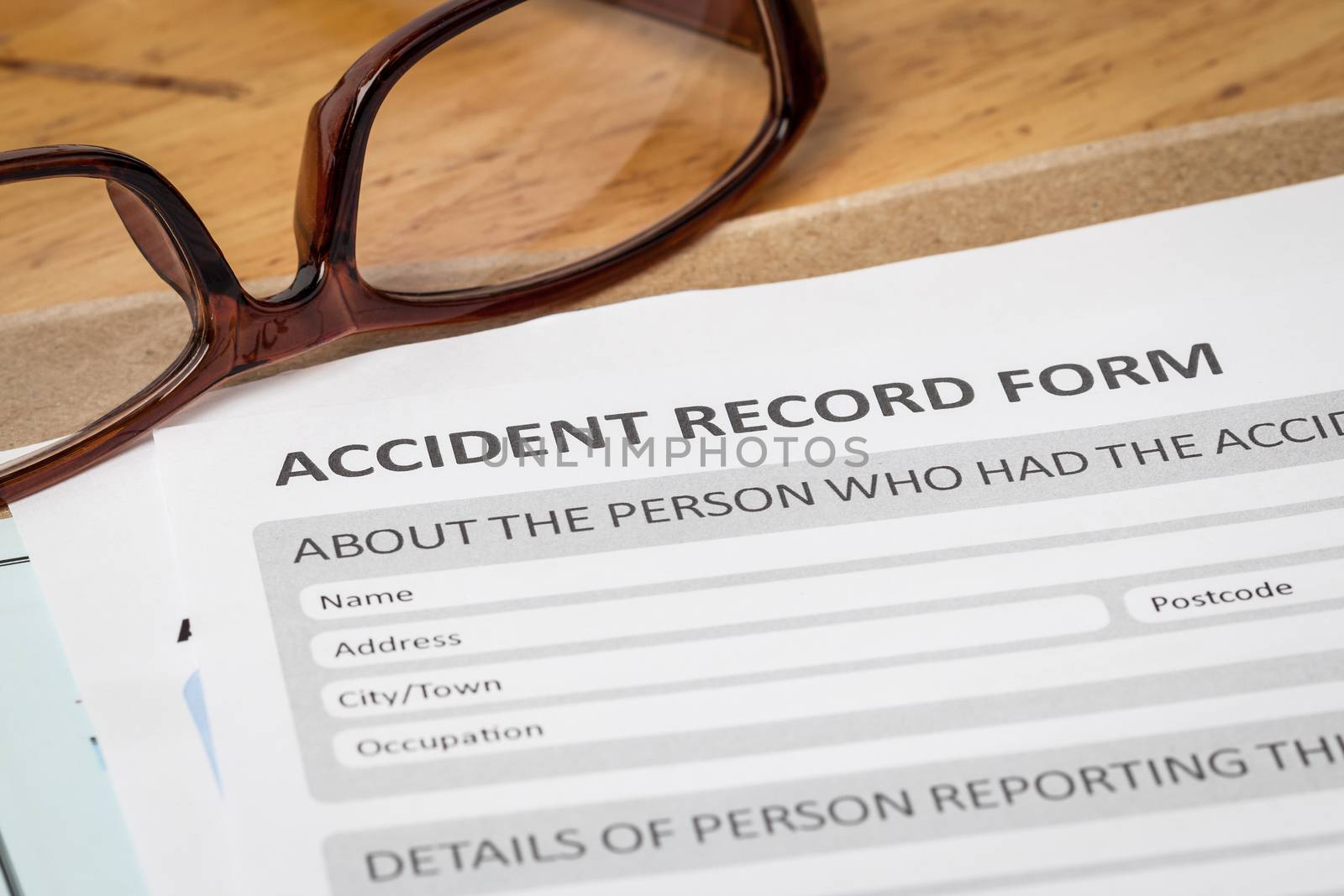 Accident report application form on brown envelope and eyeglass, by FrameAngel