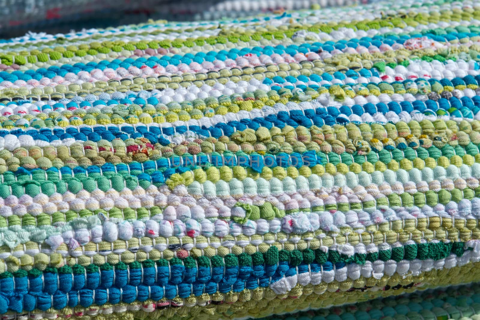 Close up colorful hand made rug carpet in blue, green and white                               