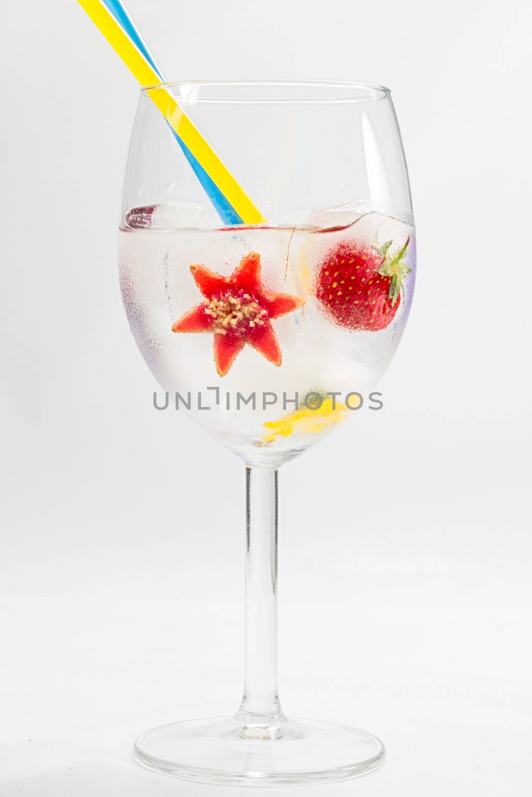 frozen fruit and flower in glass with straws