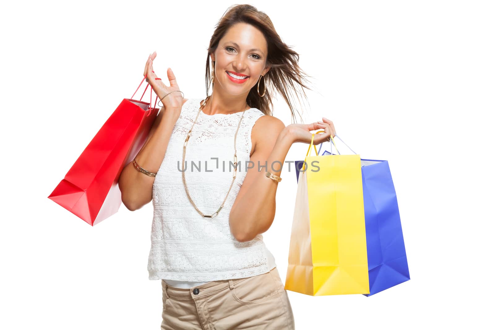 Very Happy Stylish Woman Raising Three Colored Shopping Paper Bag with Mouth Open and Looking at the Camera. Isolated on White Background.