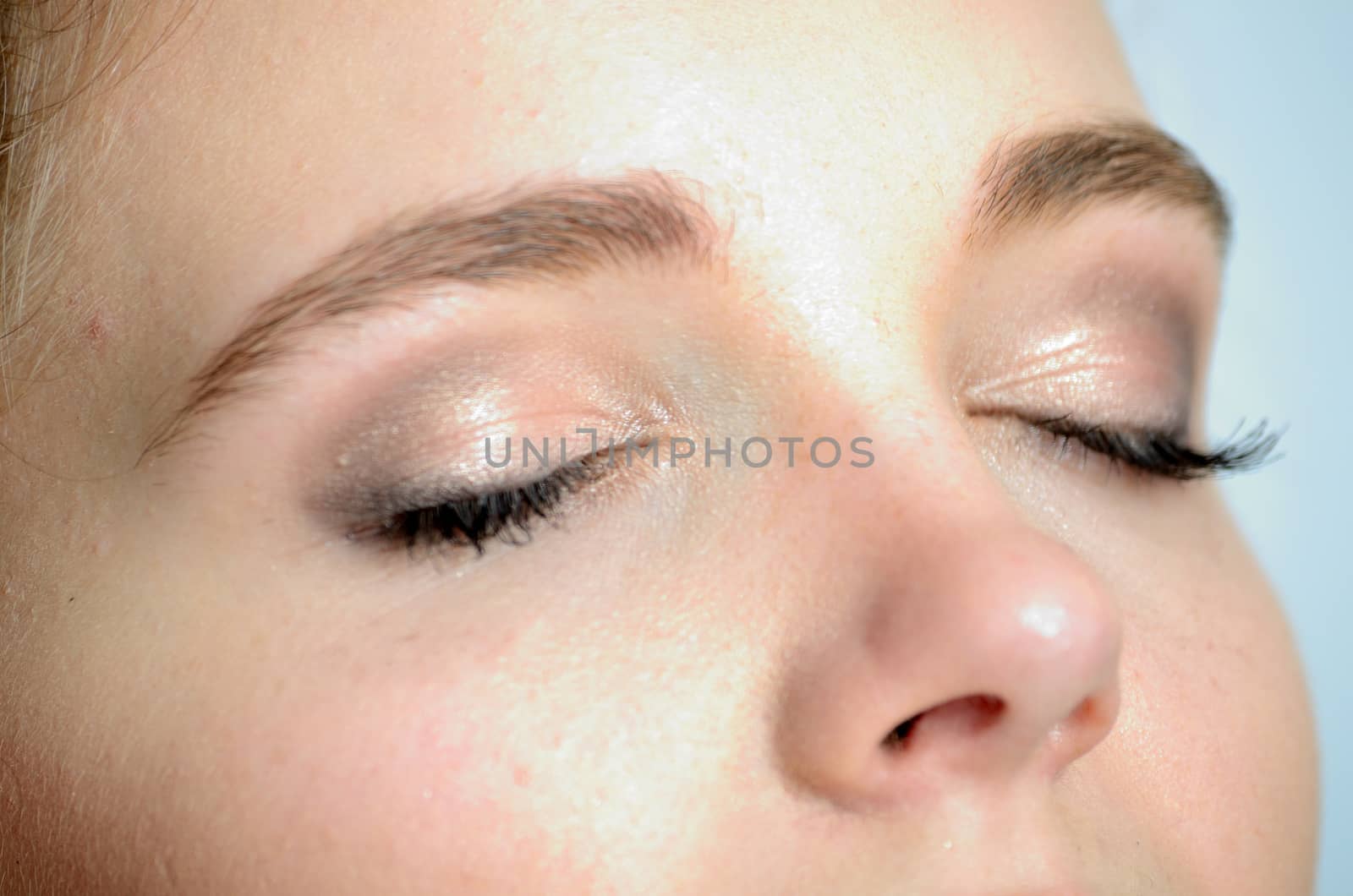 Closeup photo of young female model with closed eyes. Gentle and relaxed face expression.