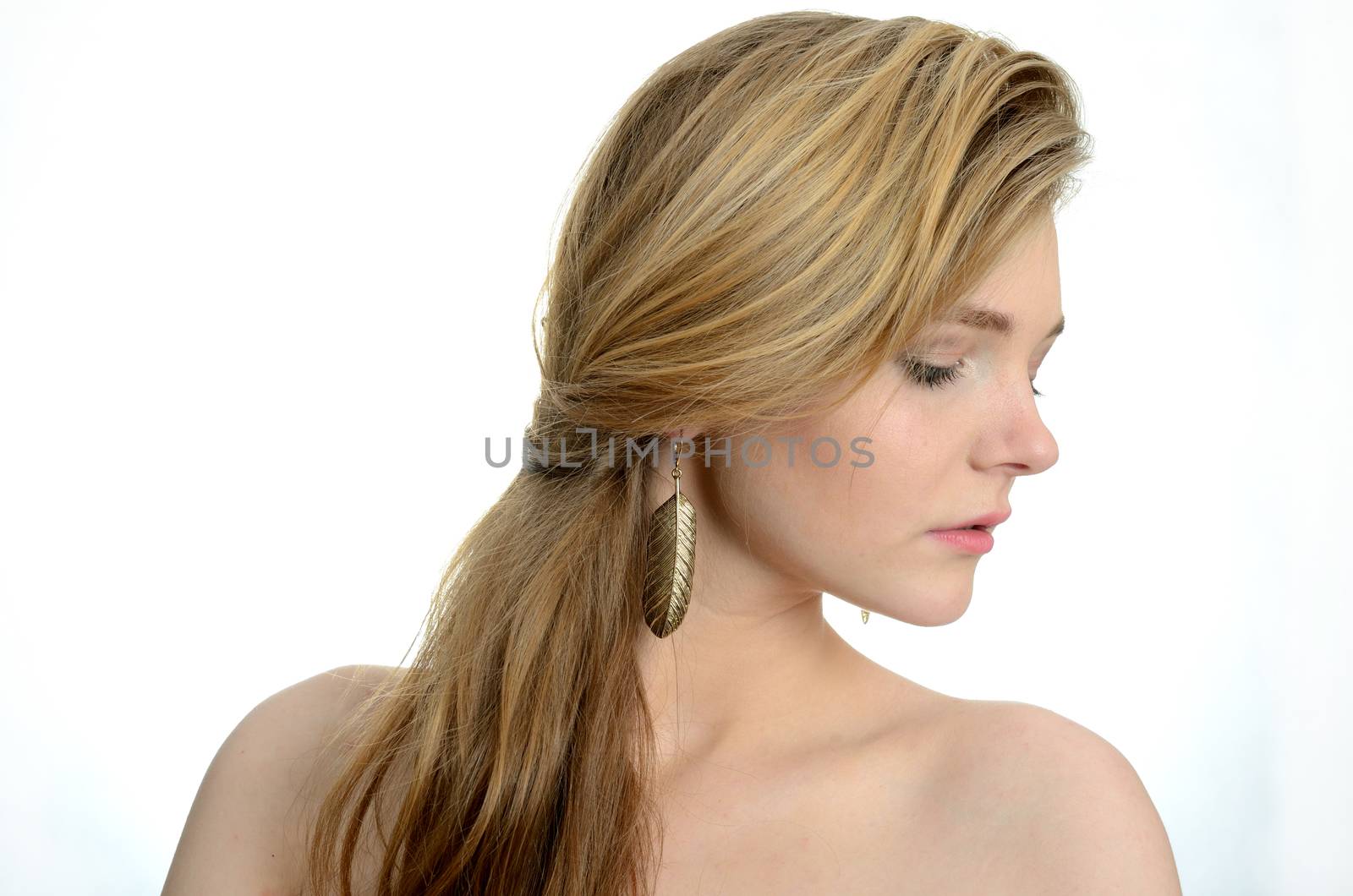 Female model portrait with golden earring. Young girl with gentle face expression.