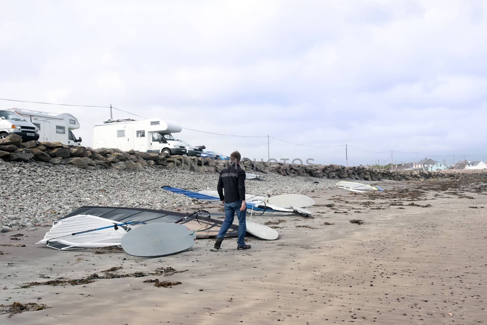 windsurfers vans and boards by the beach by morrbyte