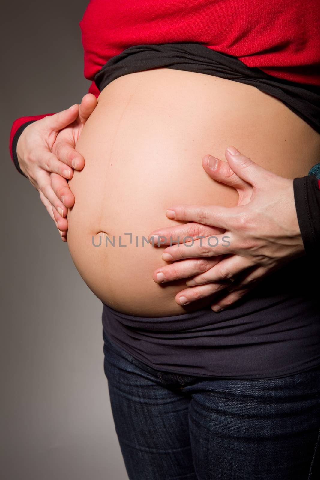 hands embrace a belly of the pregnant woman