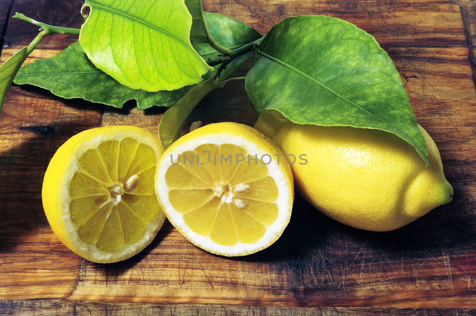 lemons with leaves on a cutting board ready to be cooked