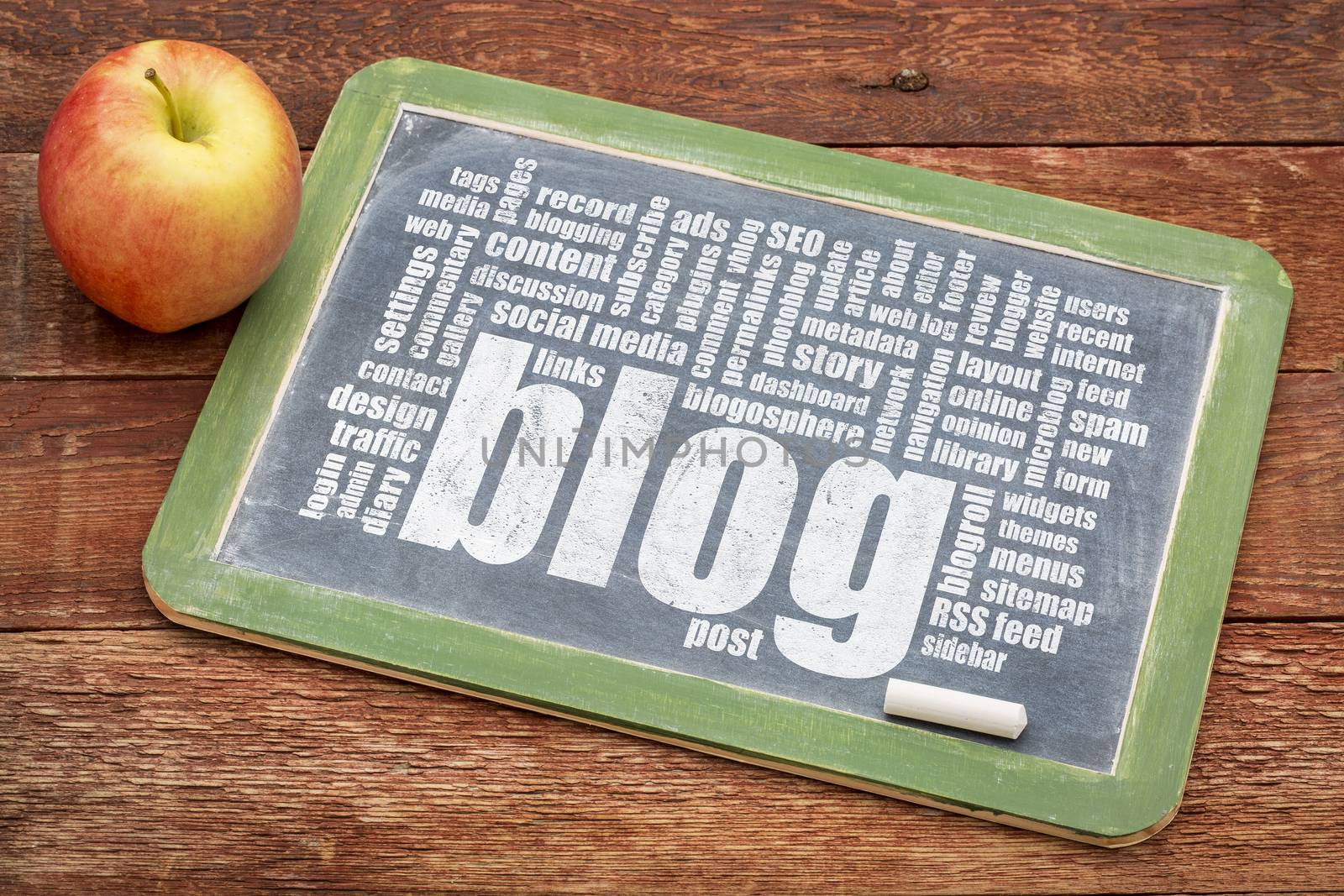 internet concept - blog word cloud on a slate blackboard with a chalk and apple