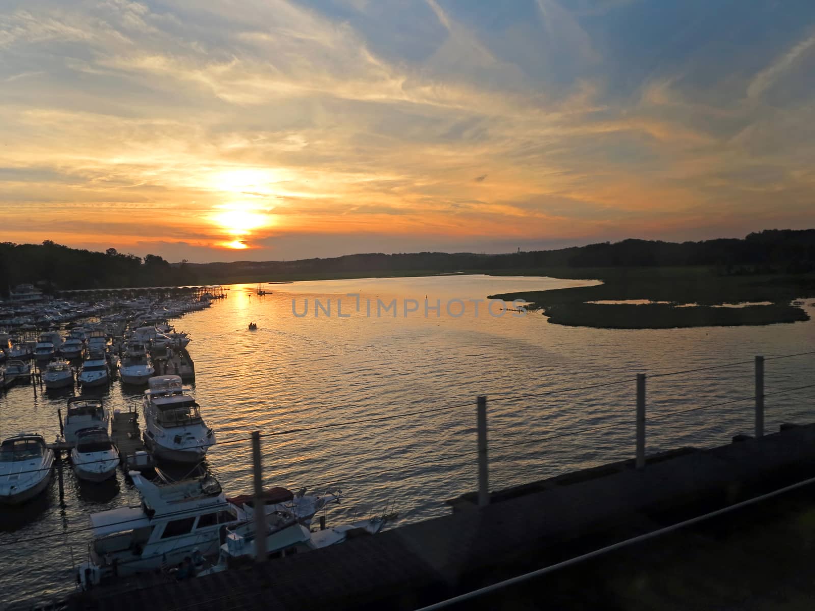 Looking at a lake with boats at sunset